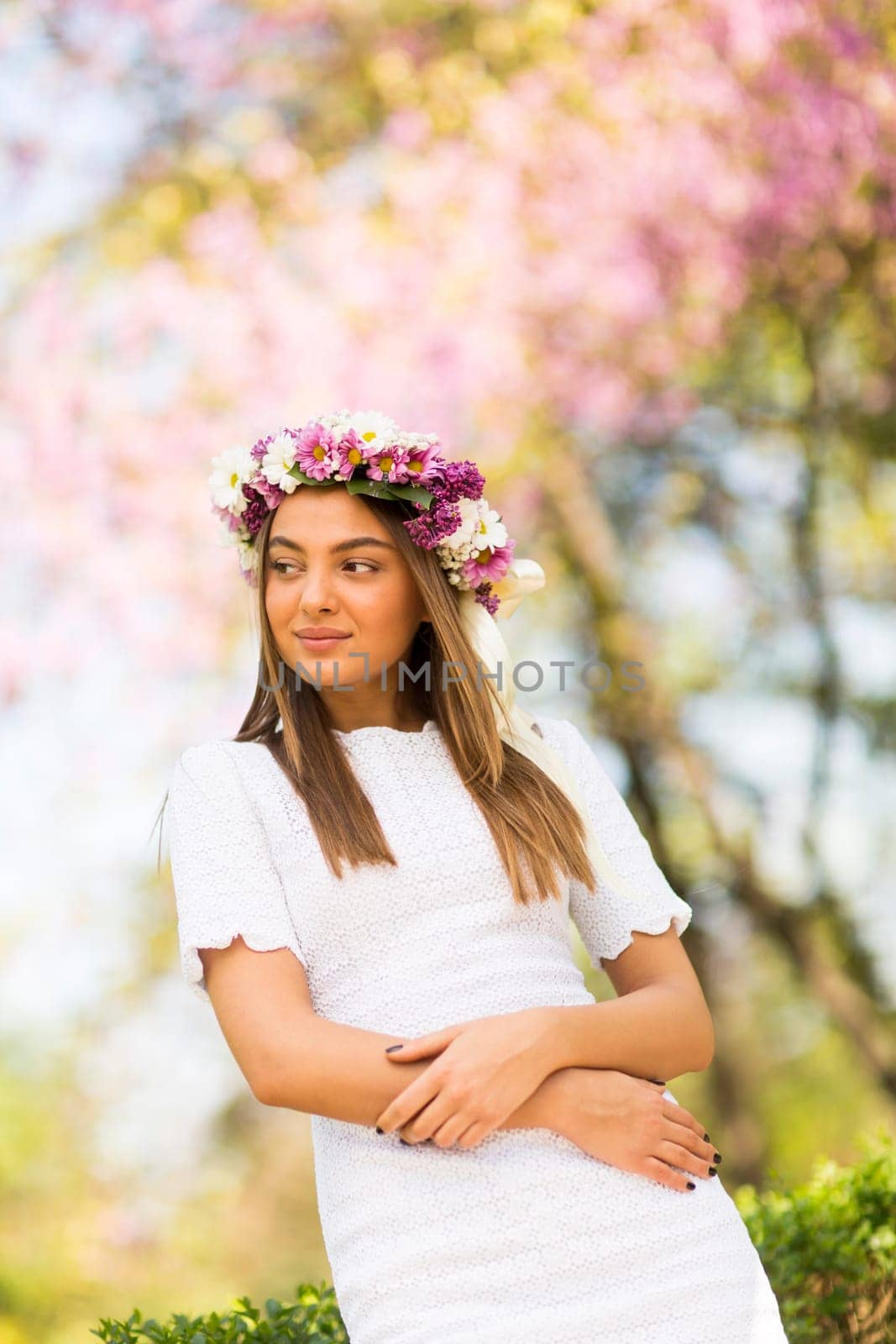 Pretty young woman with flowers in her hair on sunny spring day