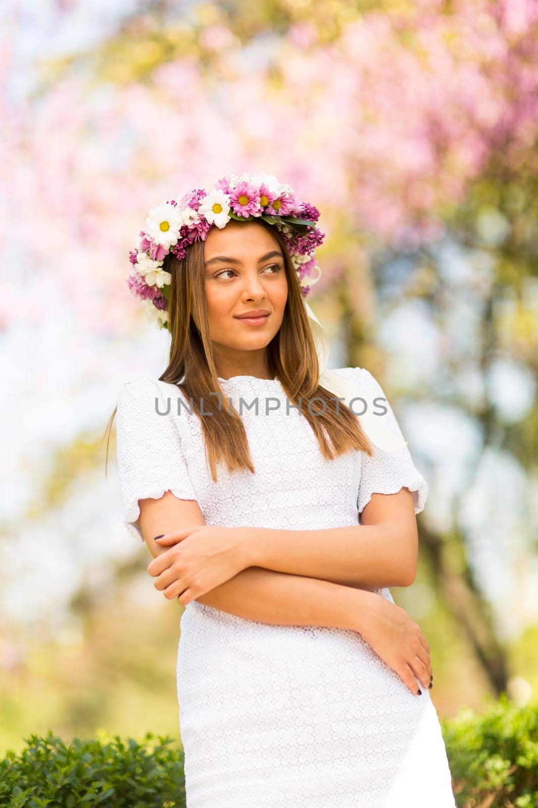 Pretty young woman with flowers in her hair on sunny spring day