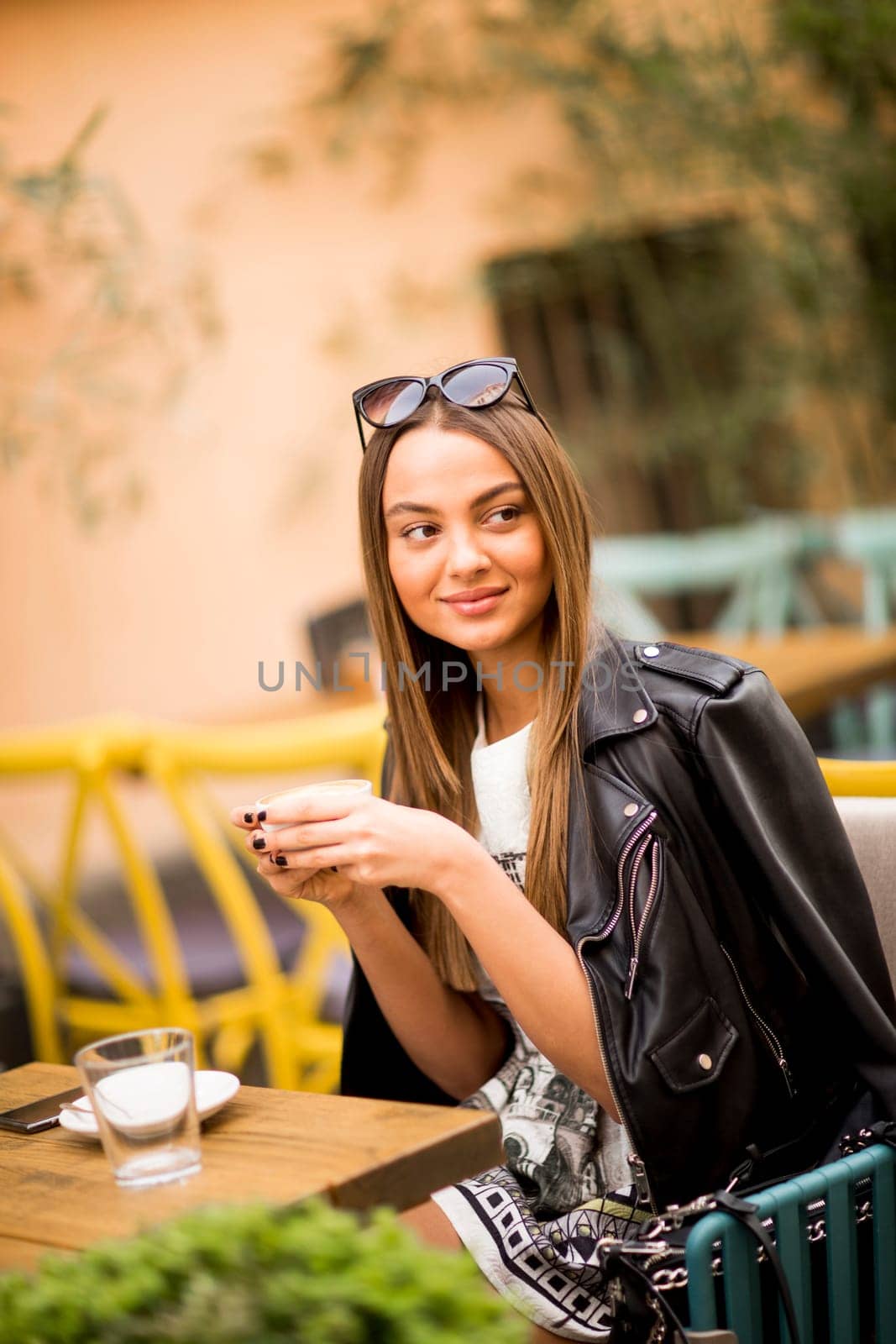 Pretty young woman drinking coffee in cafe on a sunny day