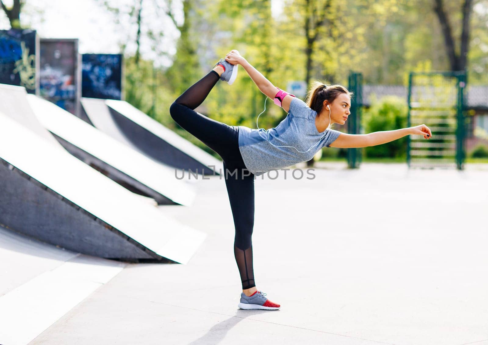 Pretty young woman stretching in the park