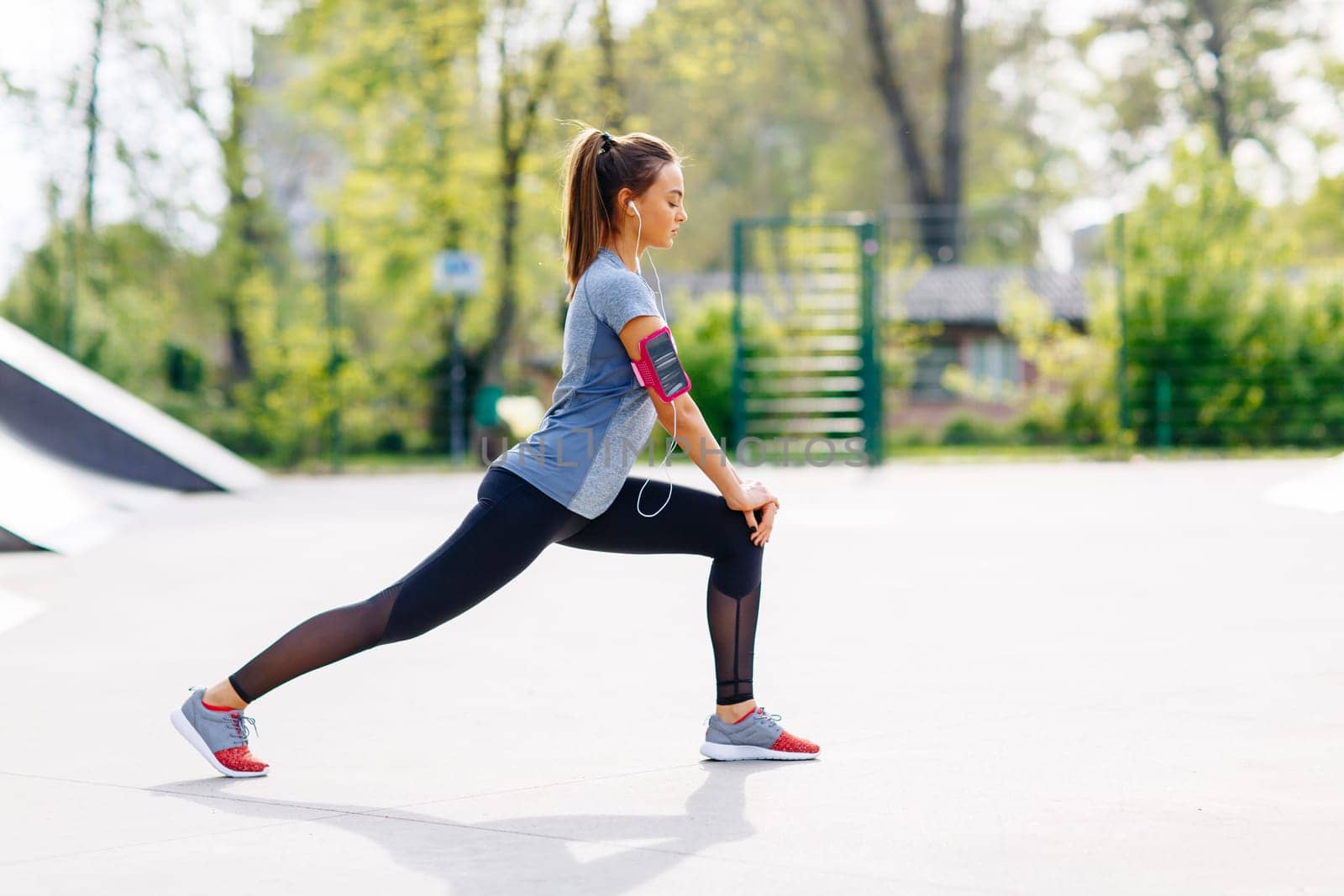 Pretty young woman stretching in the park