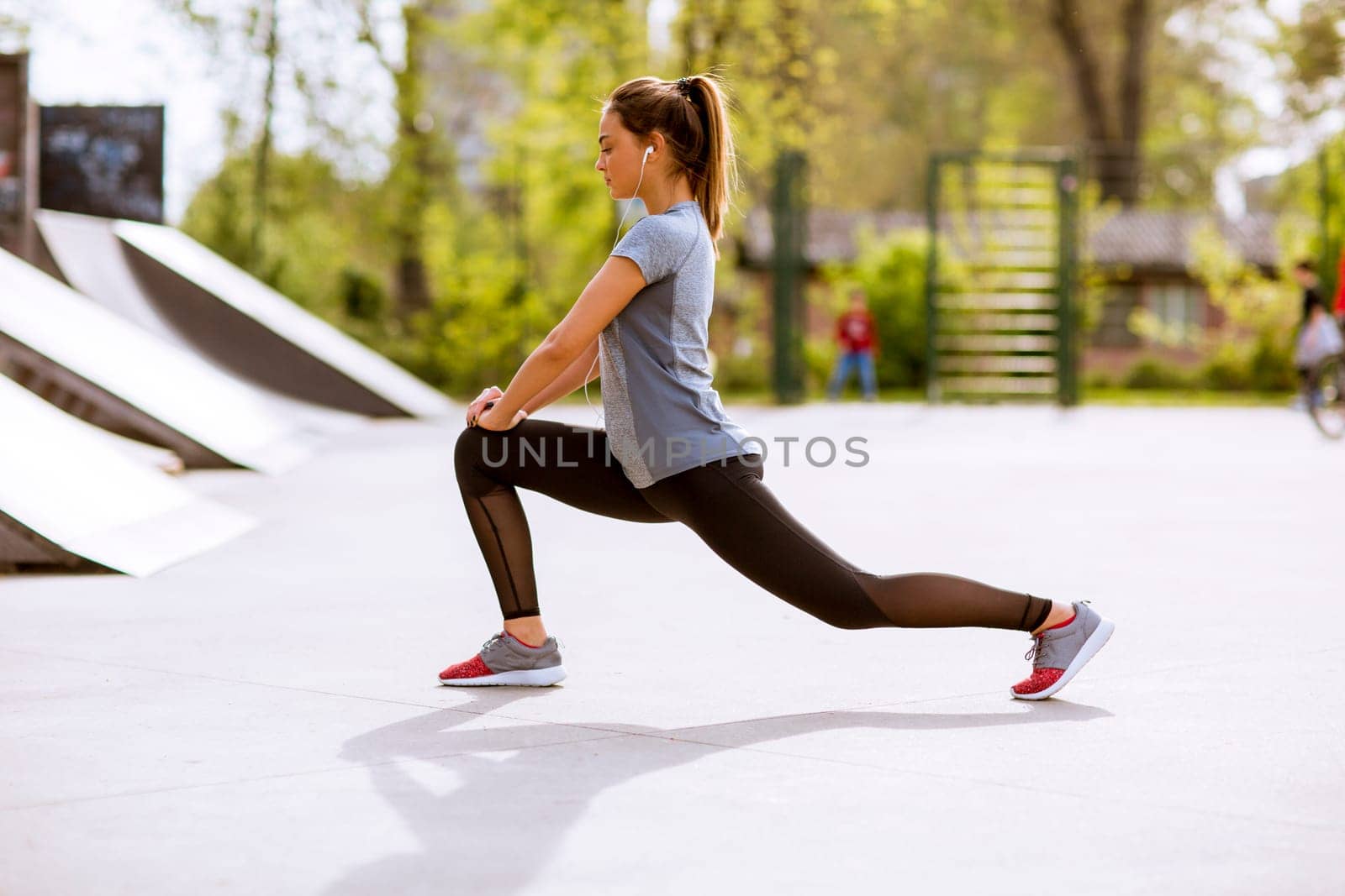 Pretty young woman stretching in the park