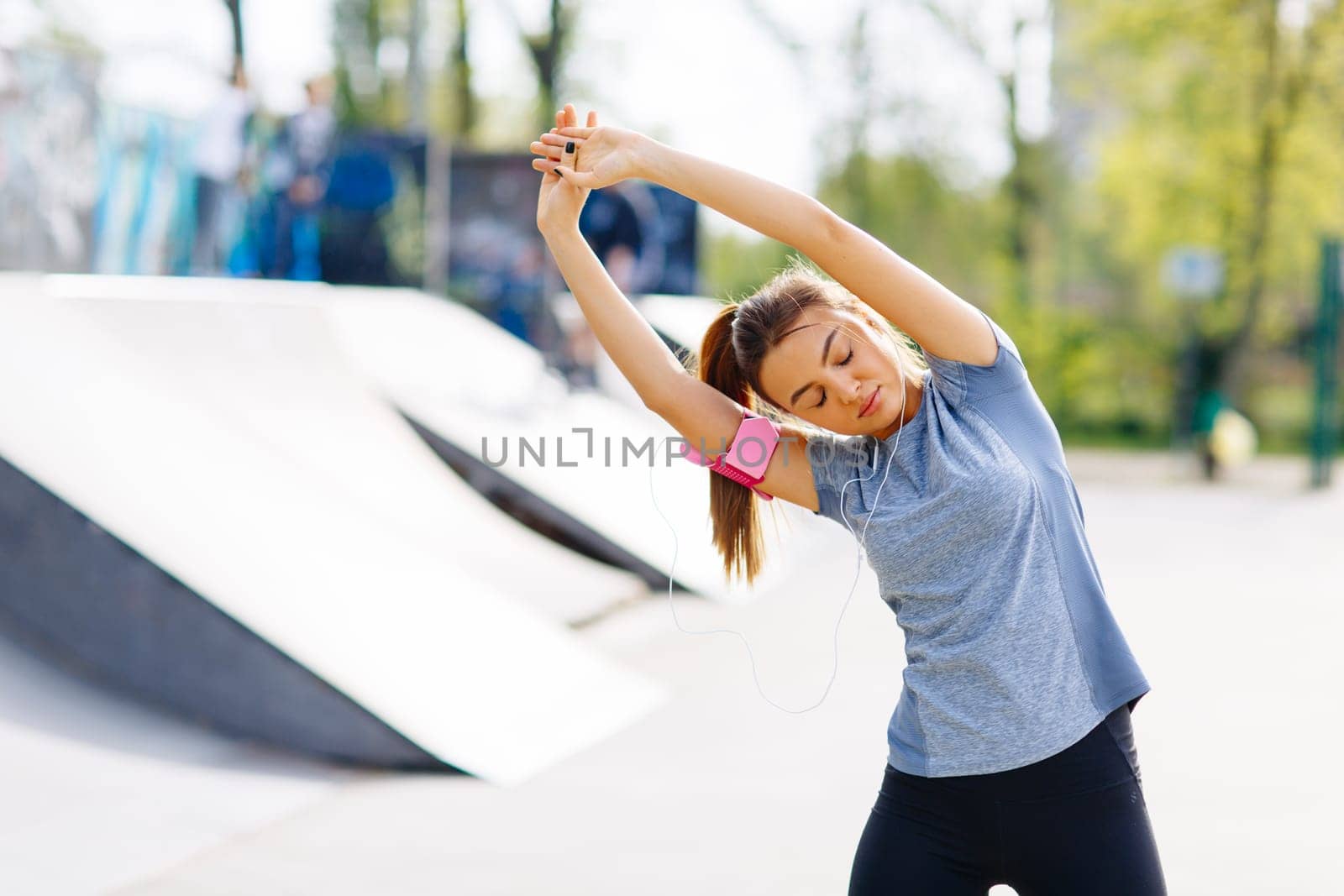 Pretty young woman having exercise in the park on a sunny day