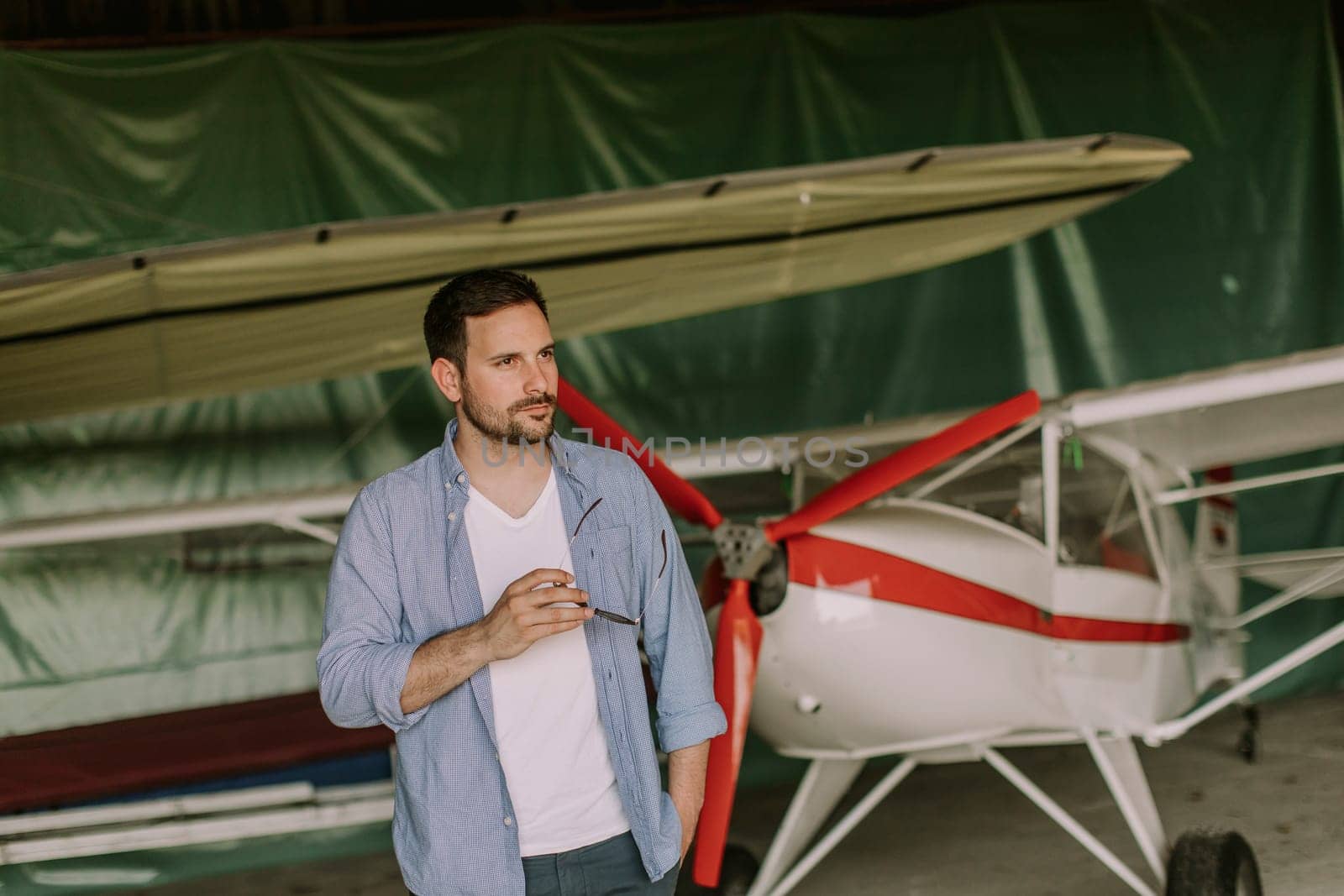 Handsome young man in the airplane hangar