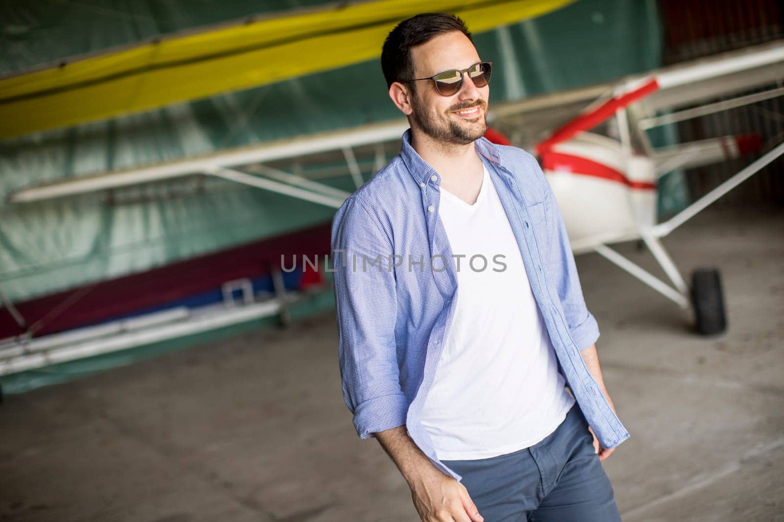 Handsome young man in the airplane hangar