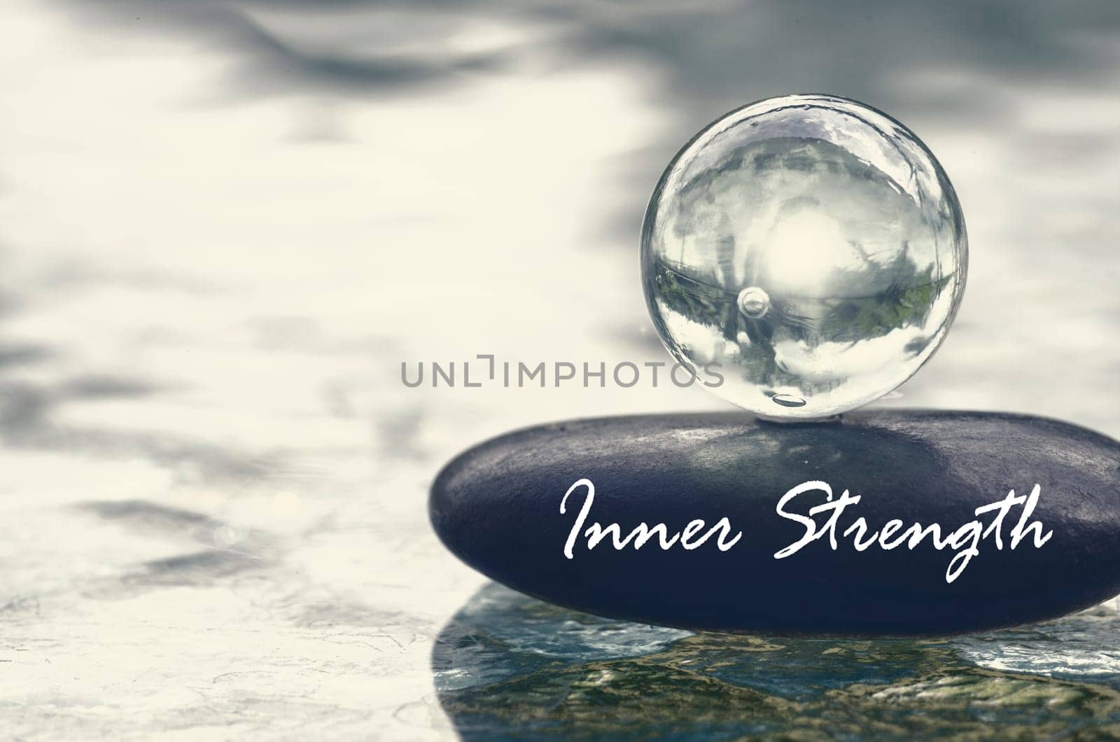 Inner Strength text on zen stone with bright shining glass marble. Inner strength concept.