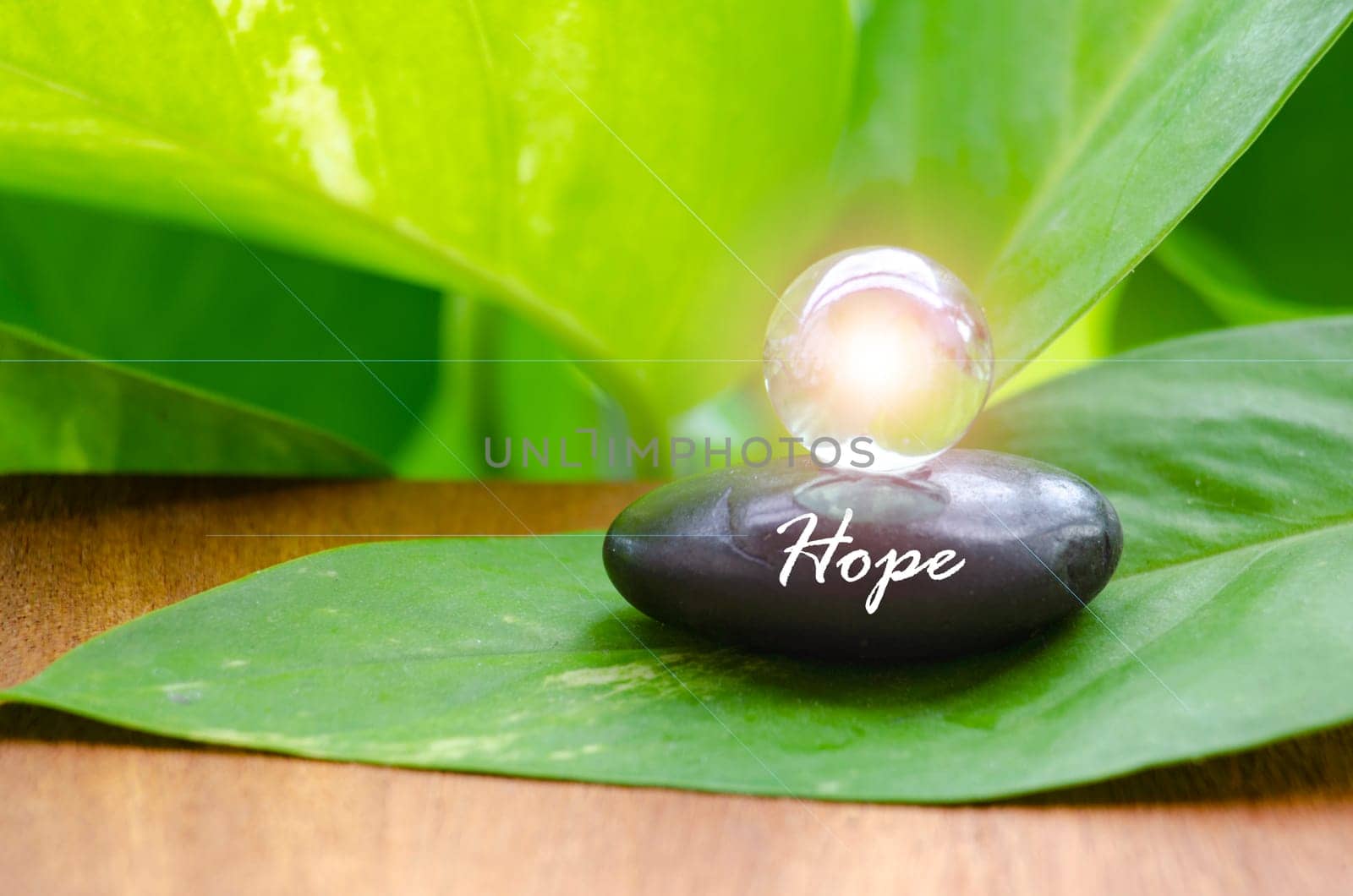 Hope text on zen stone with bright shining glass marble. Hope concept.