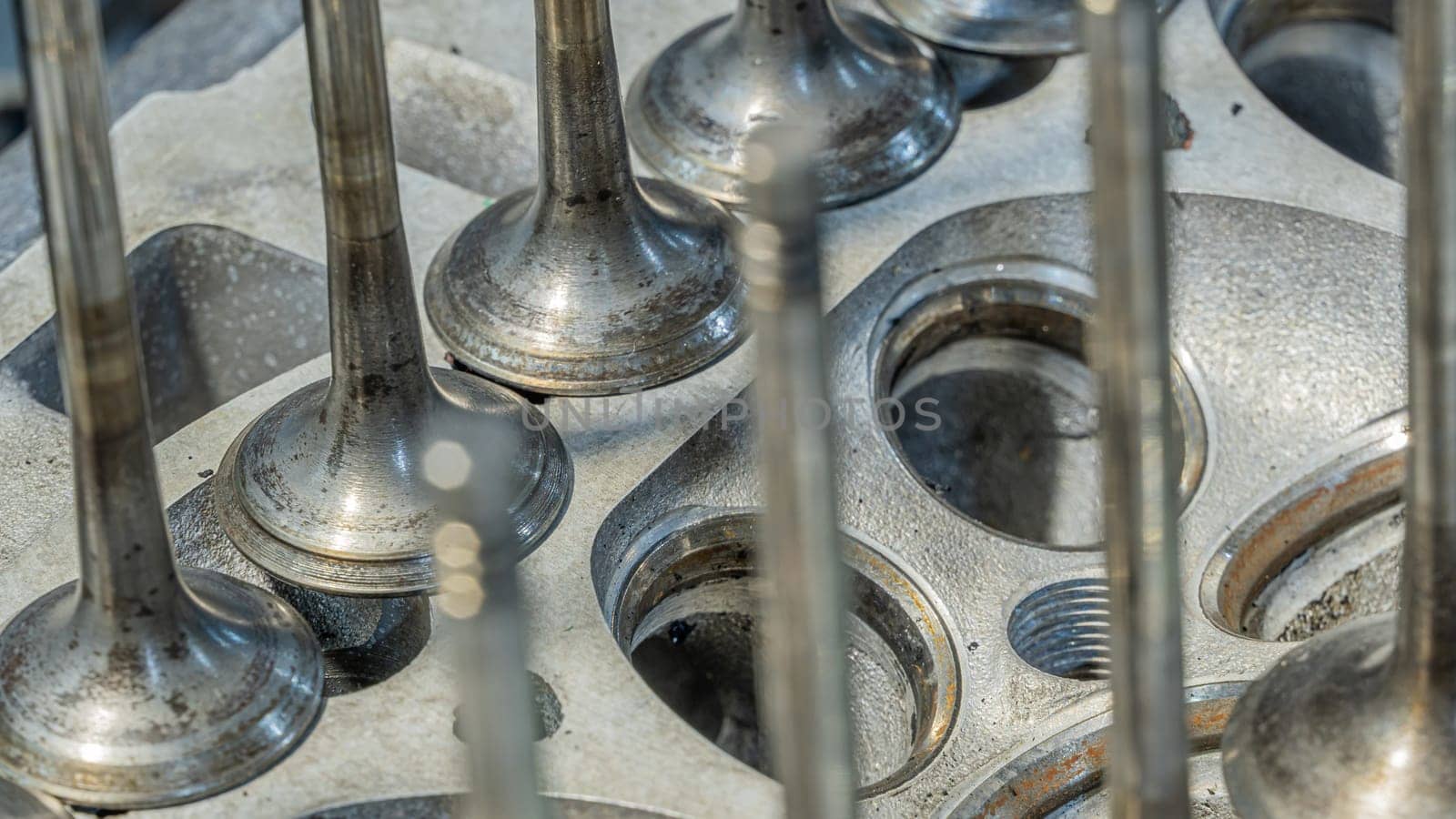 Car engine valves close up.Part of car's motor.Machinery detail of modern gasoline engine repair of cylinder head.Installing the valve of an overhauled engine.Mechanism automobile.Workshop motor car