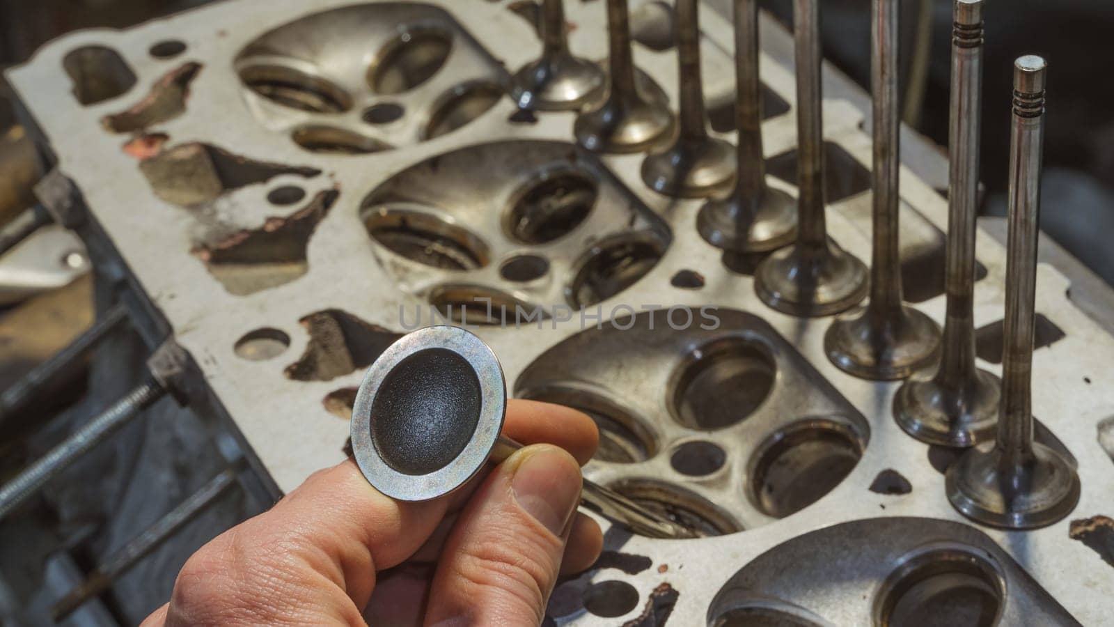 Car engine valves close up.Part of car's motor.Machinery detail of modern gasoline engine repair of cylinder head.Installing the valve of an overhauled engine.Mechanism automobile.Workshop motor car