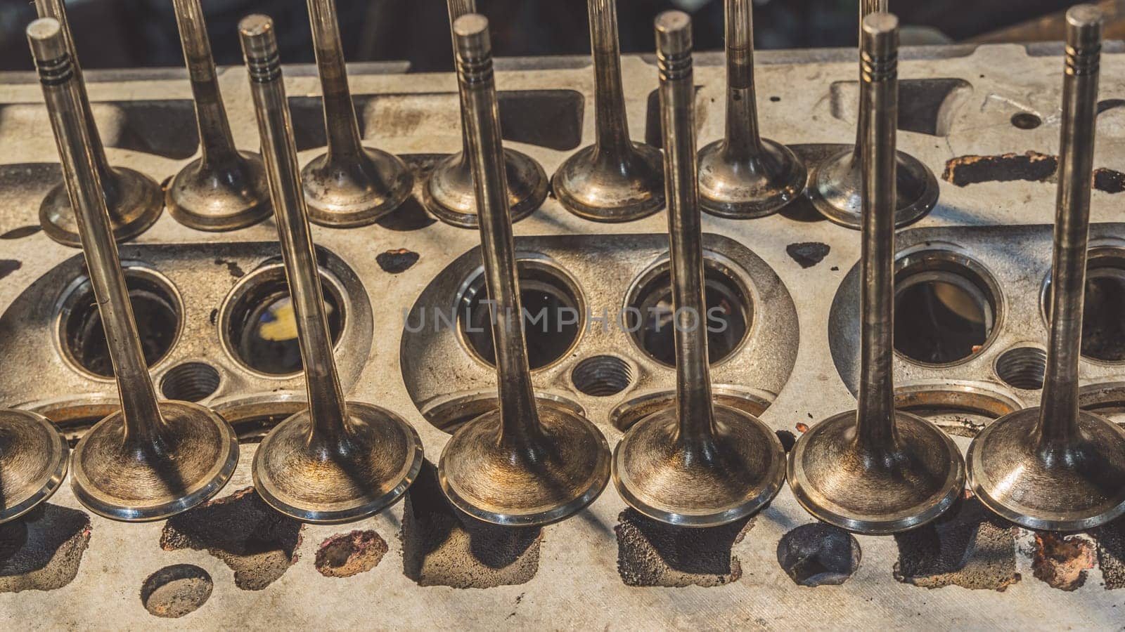 Car engine valves close up.Part of car's motor.Machinery detail of modern gasoline engine repair of cylinder head.Installing the valve of an overhauled engine.Mechanism automobile.Workshop motor car