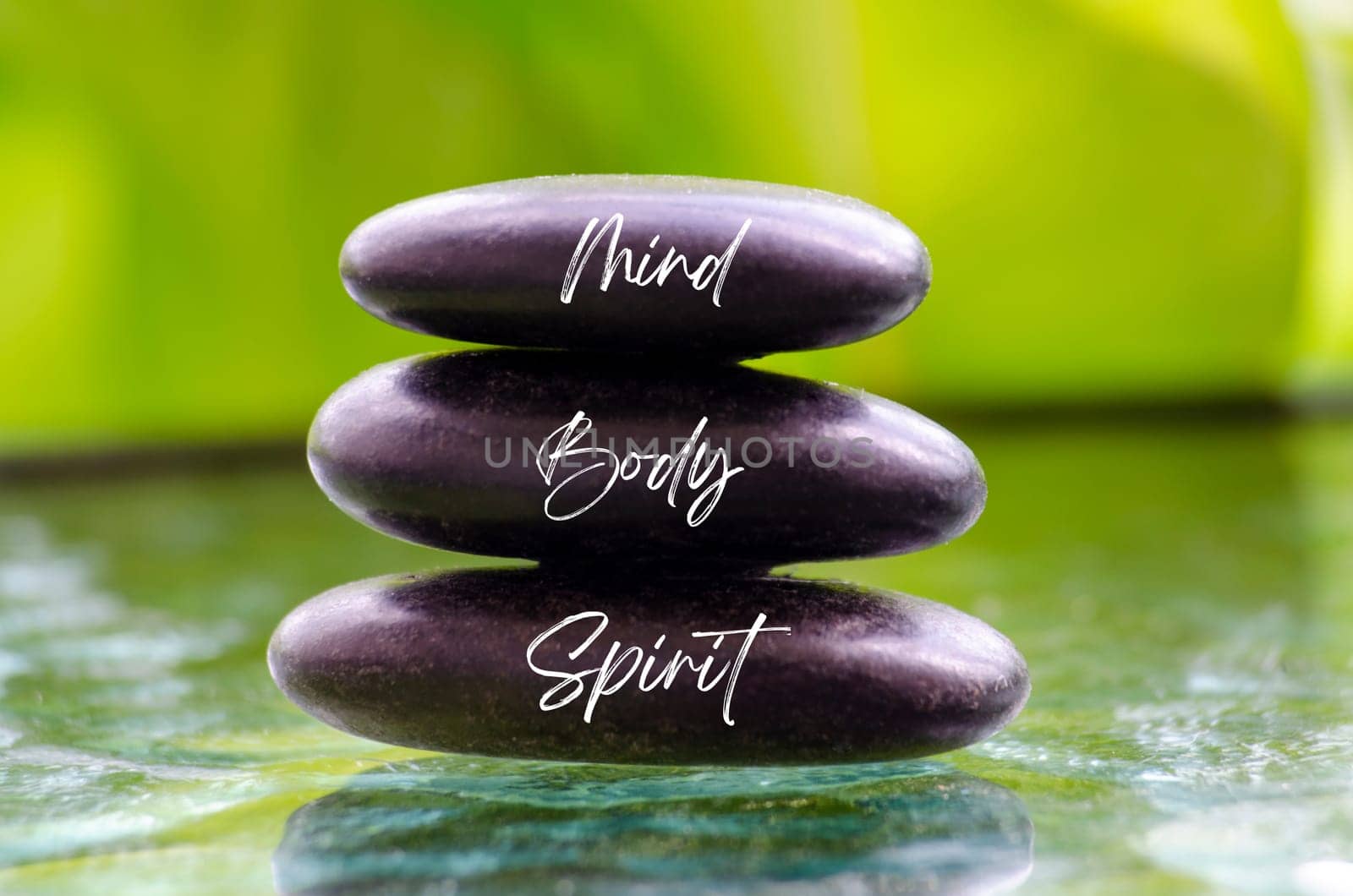 Mind Body and Spirit ext on black zen stones. Inner peace concept.
