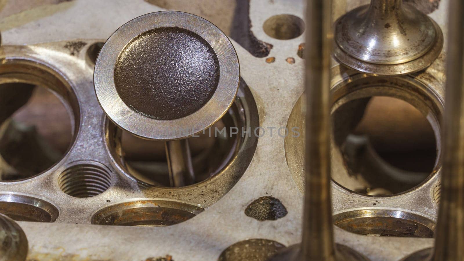 Car engine valves close up.Part of car's motor.Machinery detail of modern gasoline engine repair of cylinder head.Installing the valve of an overhauled engine.Mechanism automobile.Workshop motor car