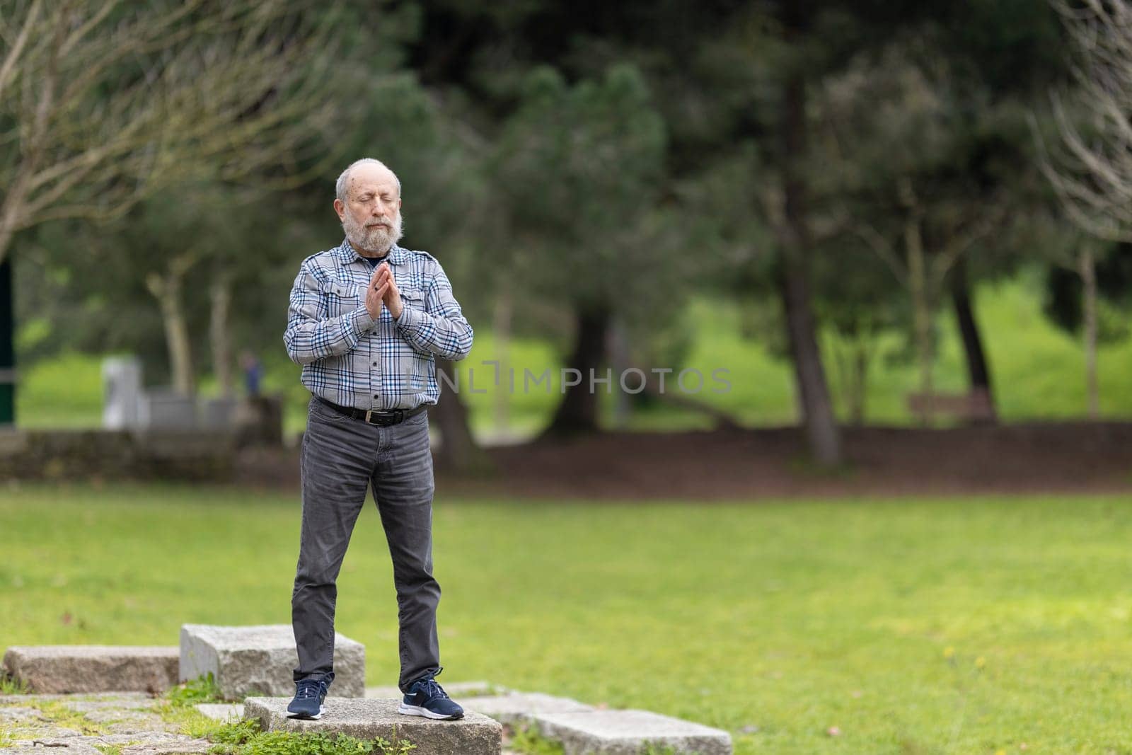 Elderly man practicing mindfulness in nature, promoting wellness and tranquility during retirement