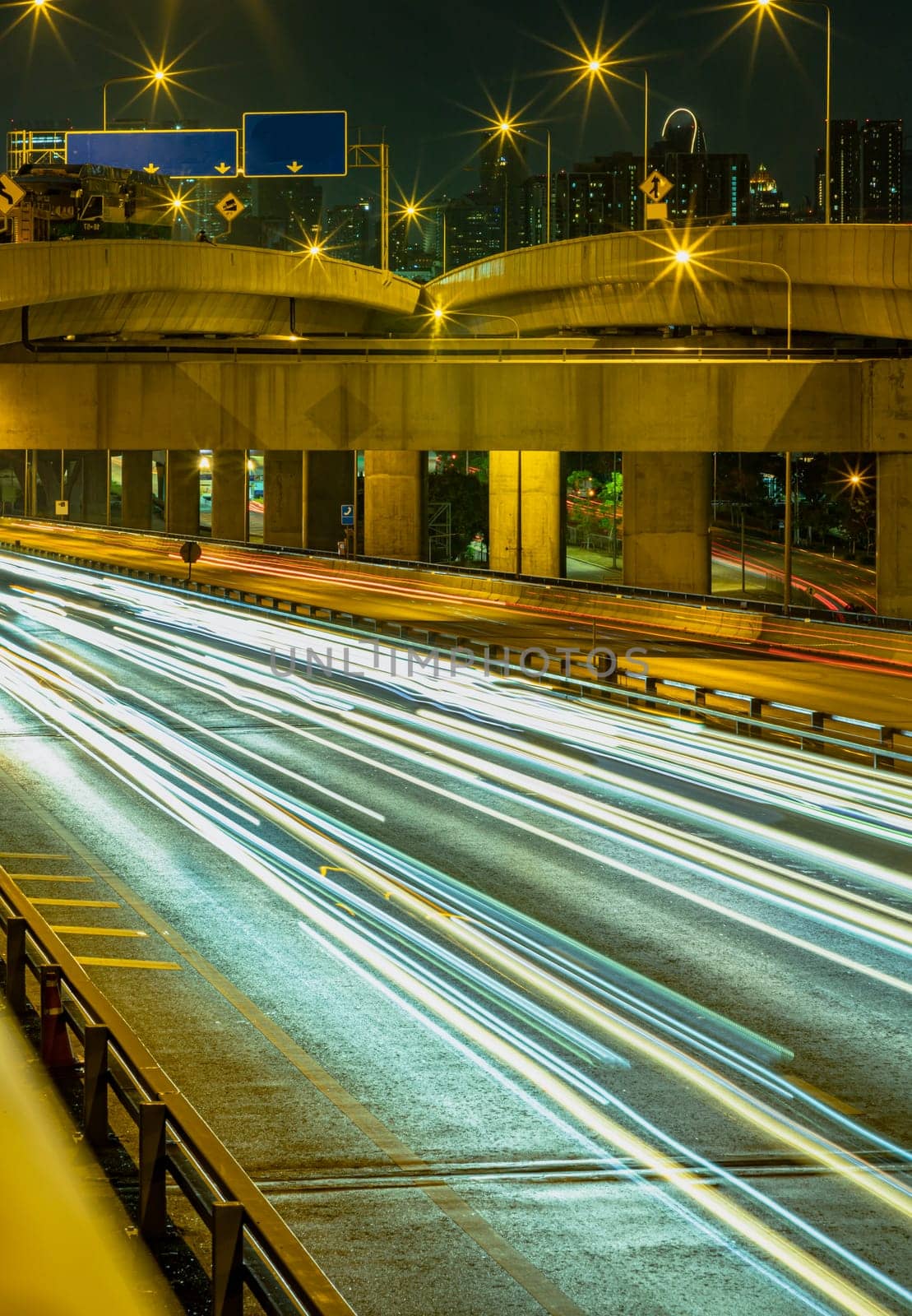 Bangkok, Thailand - Jan 10, 2025 - A nightscape view with bright glowing light trails effect of many cars headlights and rear lights on urban expressway of Bangkok. Long exposure for Light curve lines, use it as wallpaper, Poster and Copy space, Selective focus.