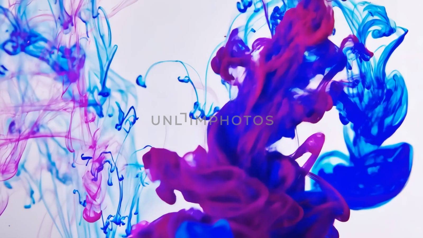 Vibrant colors of flowing ink and liquid paint mix together, forming a captivating abstract background. The fluid movement of colors creates an enchanting texture that draws the viewer in.