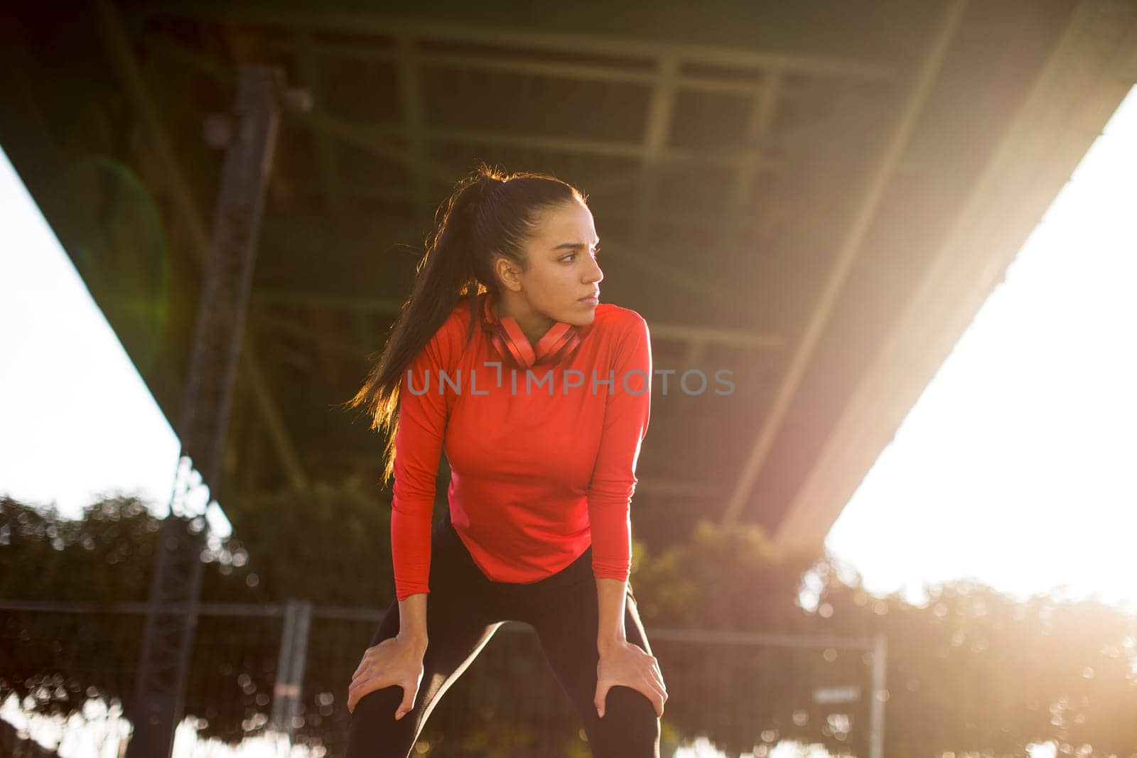 Attractive young female runner taking break after jogging outdoors