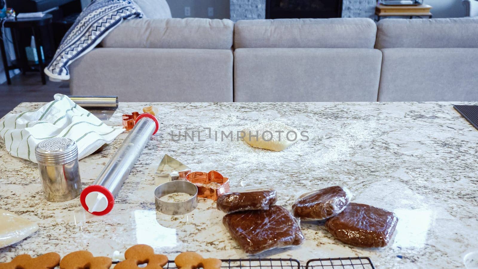 Using an adjustable rolling pin to roll out gingerbread cookie dough on the elegant marble counter in a modern kitchen, getting ready for festive holiday baking.