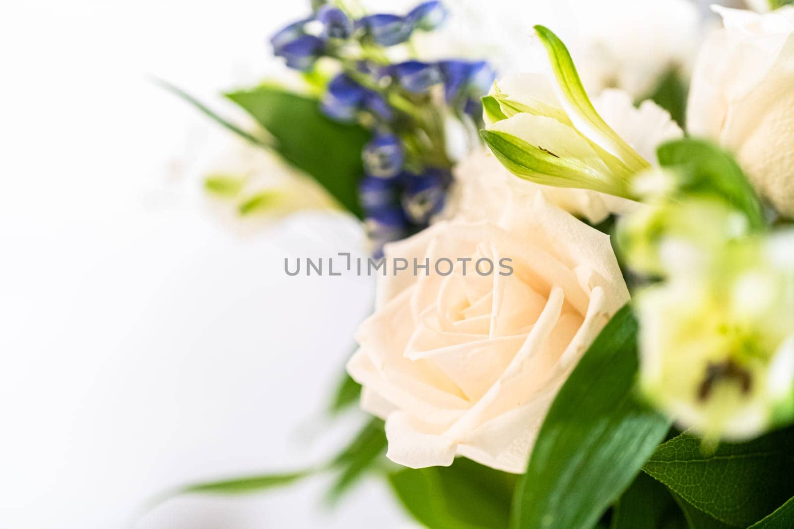 A stunning bouquet featuring fresh white roses and assorted flowers gracefully arranged in a vase, exuding timeless beauty.