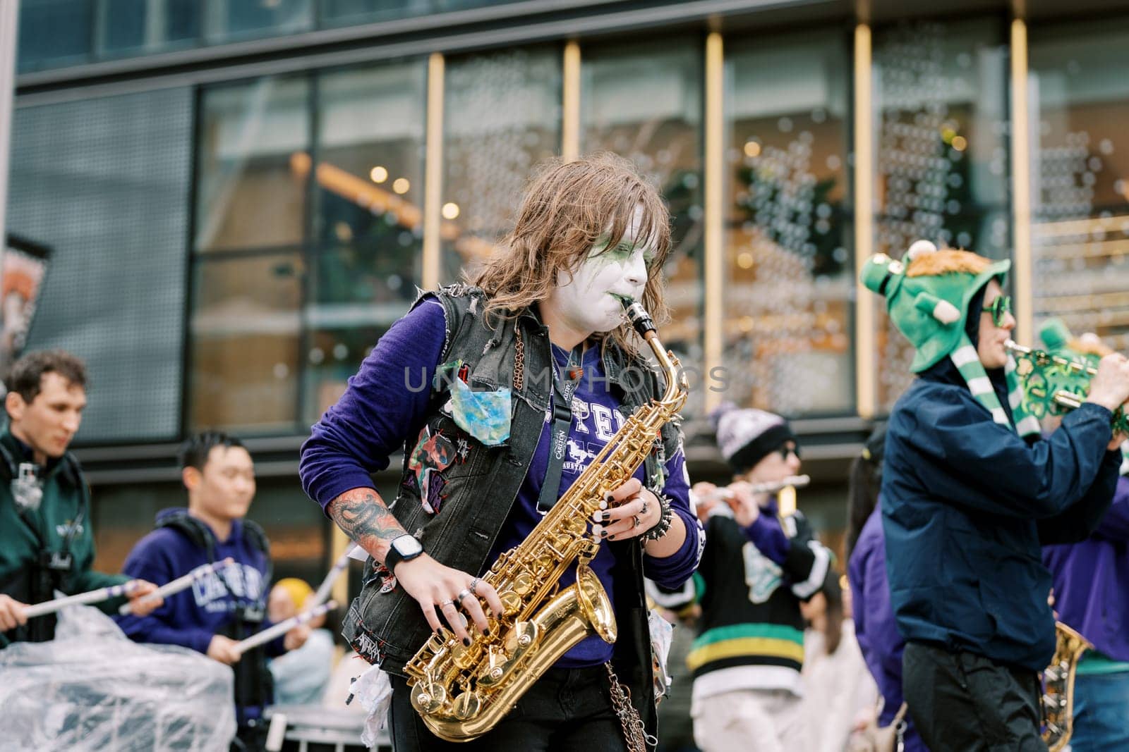 An energetic performer skillfully playing his saxophone at a lively street festival