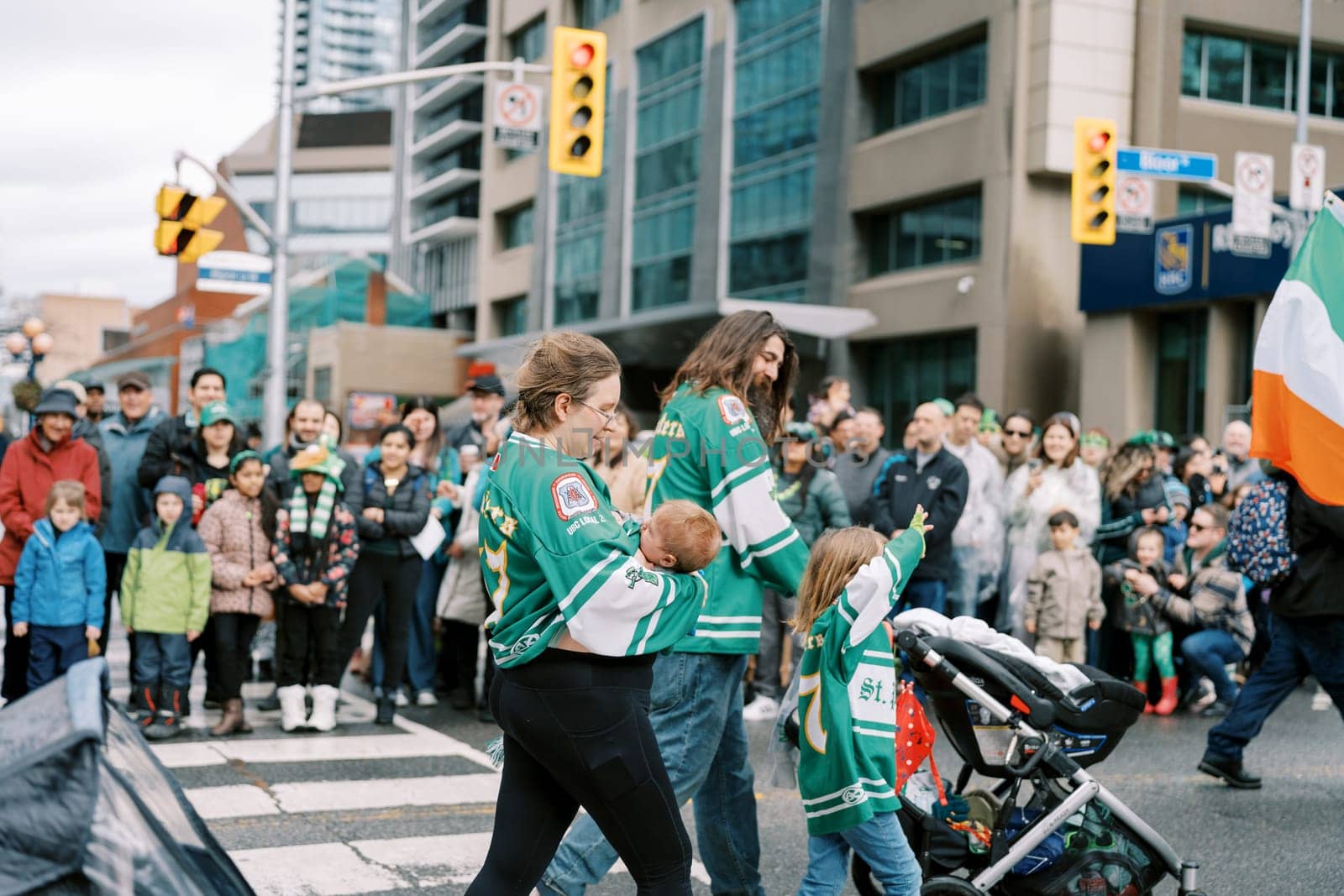 Families enjoy a cultural parade with vibrant green jerseys and excitement