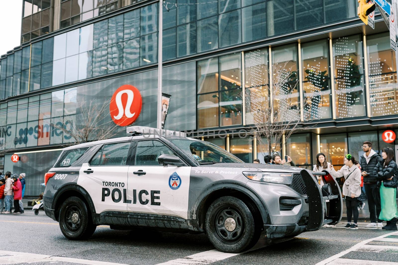 A police SUV skillfully navigates a bustling urban area filled with pedestrians