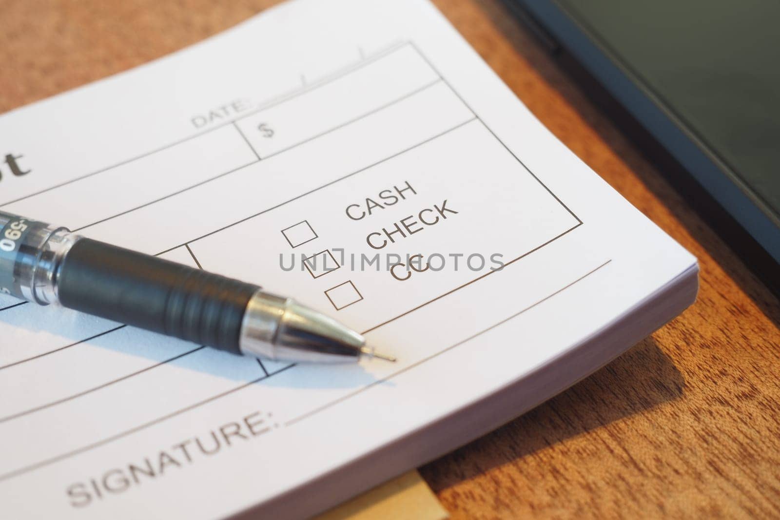 Close-up of a document showing payment method choices and a pen.
