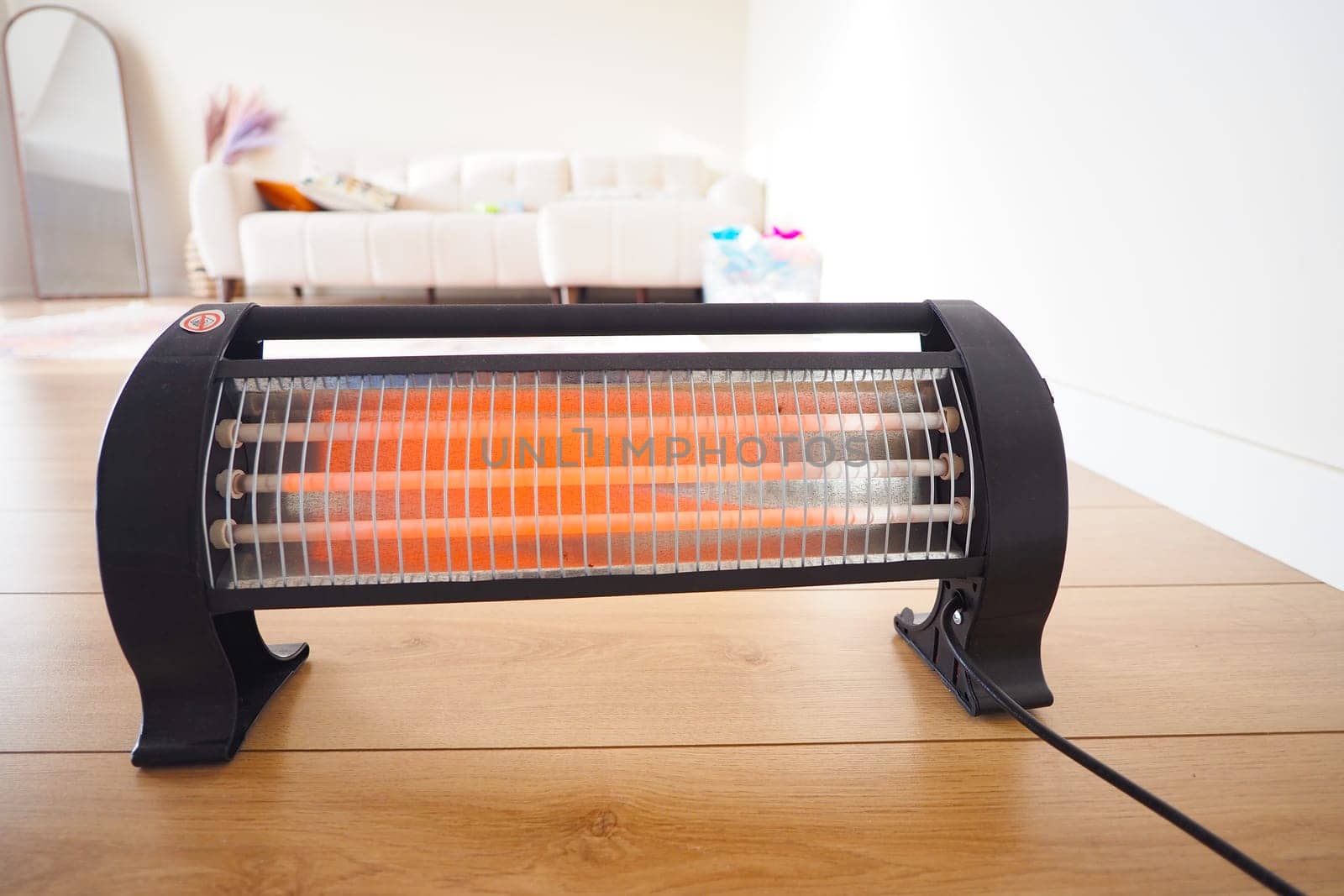 A space heater emits warmth in a cozy, well-lit living area during winter.