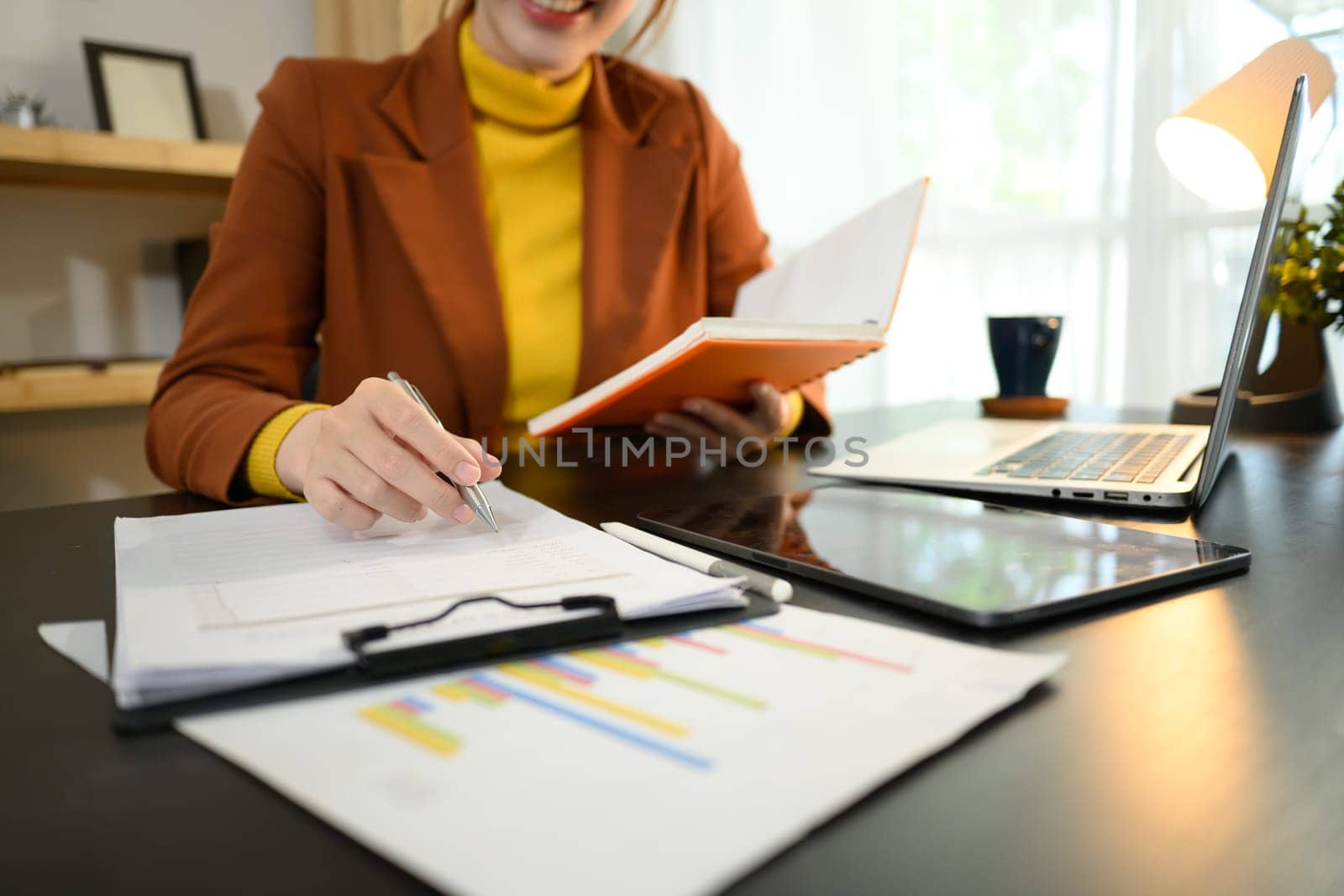 Cropped shot reviewing financial charts and documents.