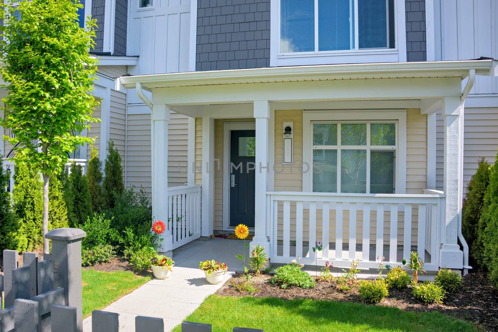Residential townhouse with open patio under the porch. Attached residential house on bright sunny spring day