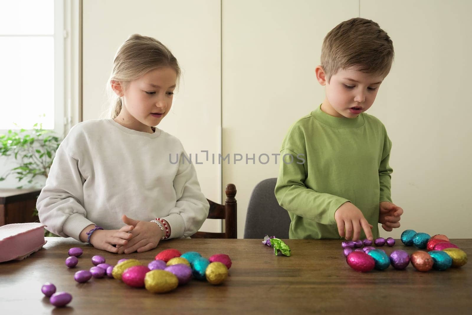 Children at home collect chocolate eggs