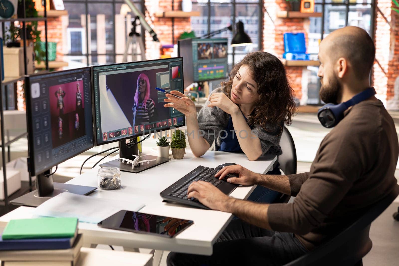 Man and woman creative team using AI to generate image models, operating an editing software to enhance digital materials and create quality content. AI assistant with photo retouching.