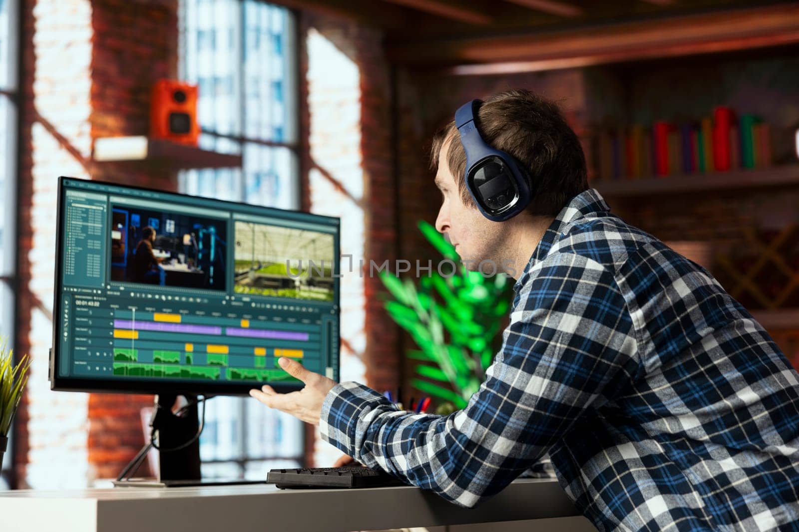 Freelancing video editor working from home trimming footage segments, working on promotional clip. Teleworking videographer splicing video pieces, editing them using professional software on PC