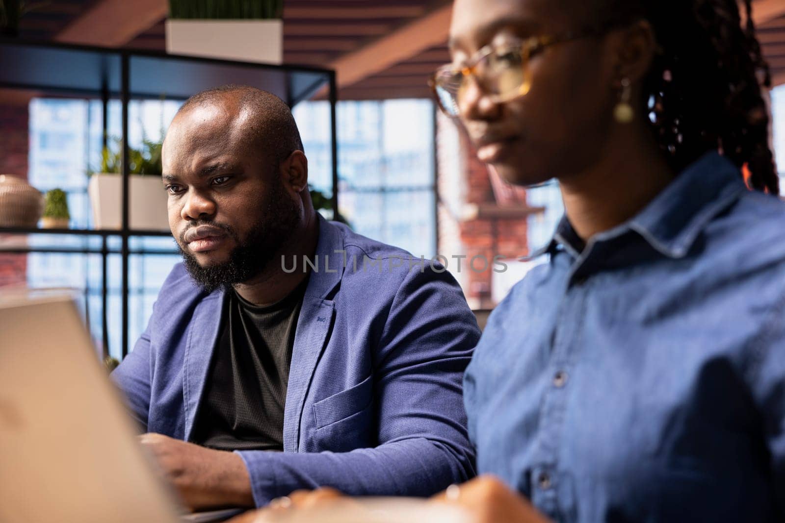 African American couple in their home office collaborate on a business project, using teamwork and digital online tools to enhance efficiency and career growth. Solving freelancing tasks.