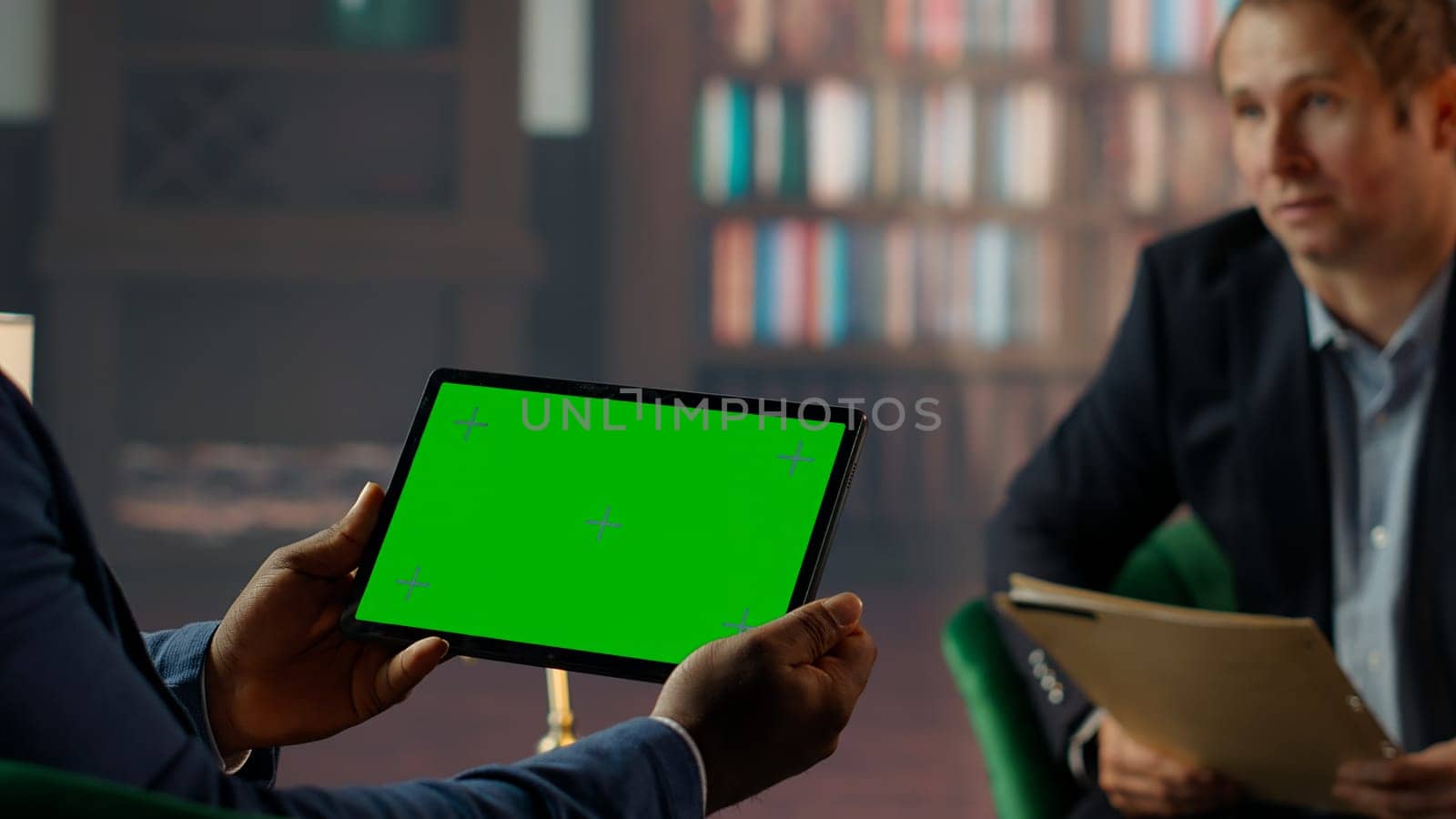 Team of skilled agents engaging in a strategic meeting with chroma key screen, emphasizing professionalism and discretion in a government mission. CIA staff gathering data. Camera B.