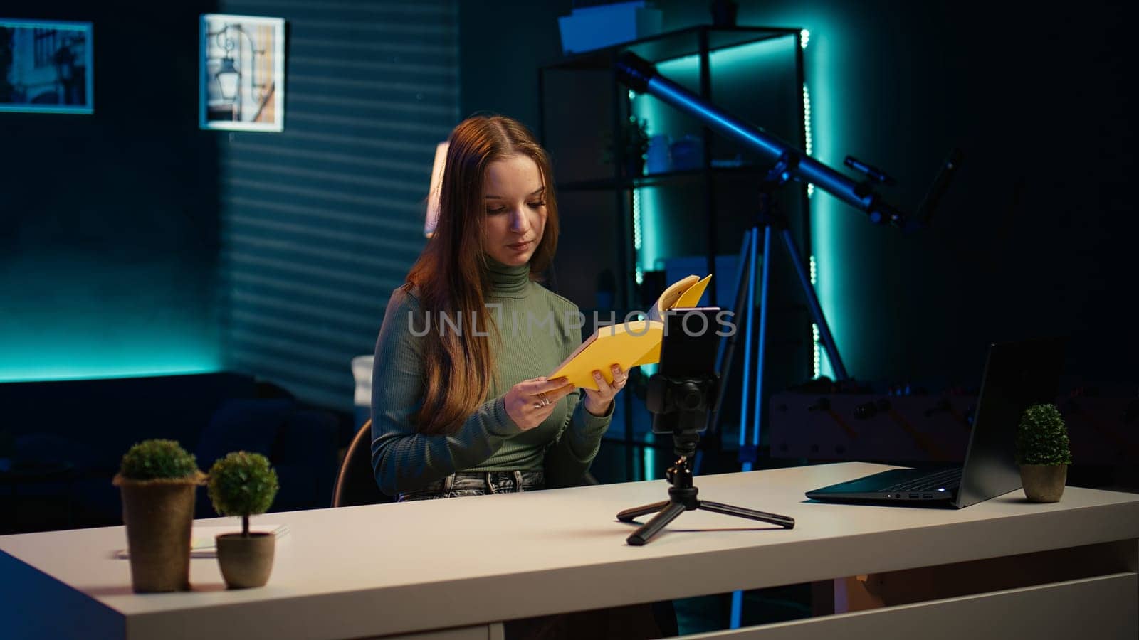 Young influencer filming review of light bulb able to change into different colors. Content creator showcasing smart home automation technology in apartment studio, camera B