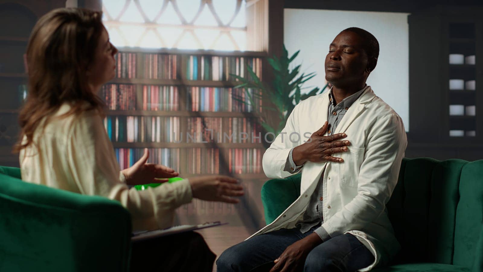 Psychiatrist in a serious conversation with a medic practitioner, listening to medical career difficulties and mental health struggles. Powerless doctor discussing about PTSD in therapy. Camera B.