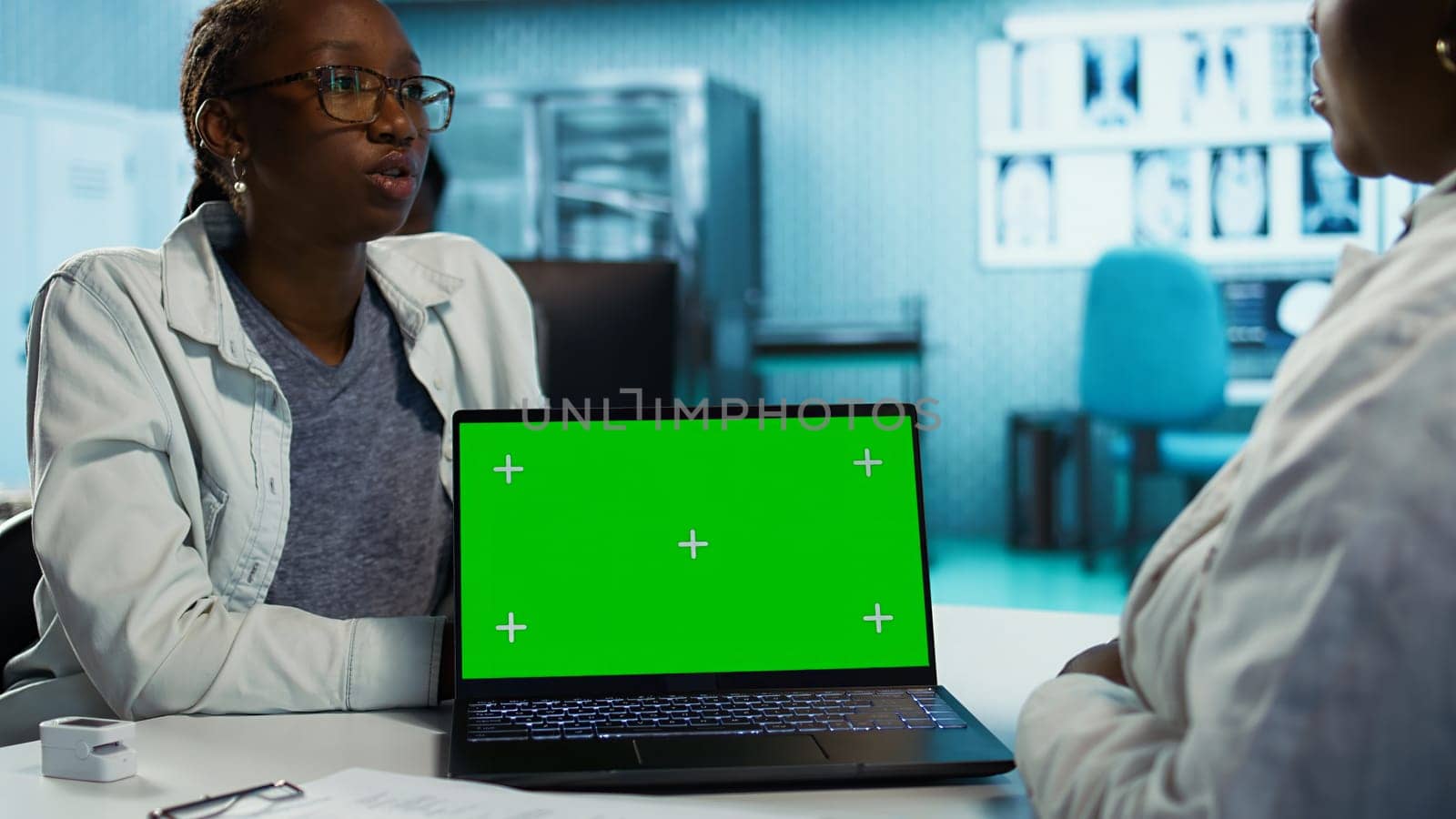 General practitioner consulting a black girl for treatment and diagnostic results, leveraging health data and expertise in a clinic environment. Medic helping with recovery. Camera B.