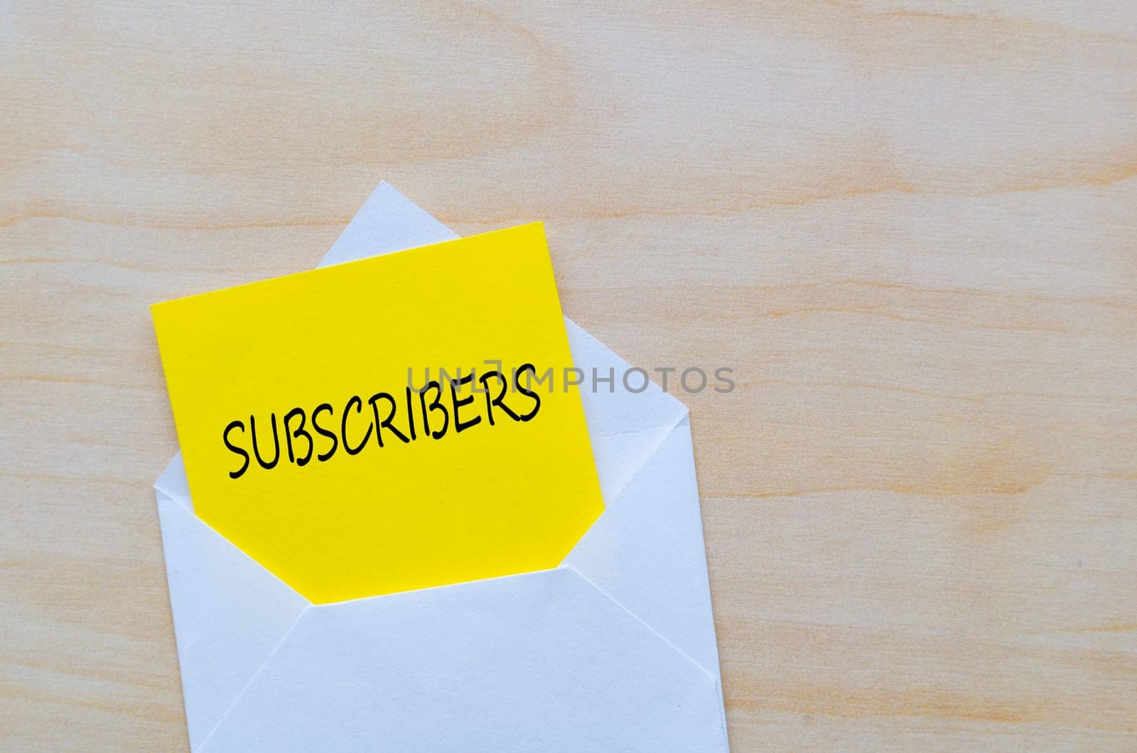 Subscribers text on yellow notepad inside a white envelope. Making money online concept.