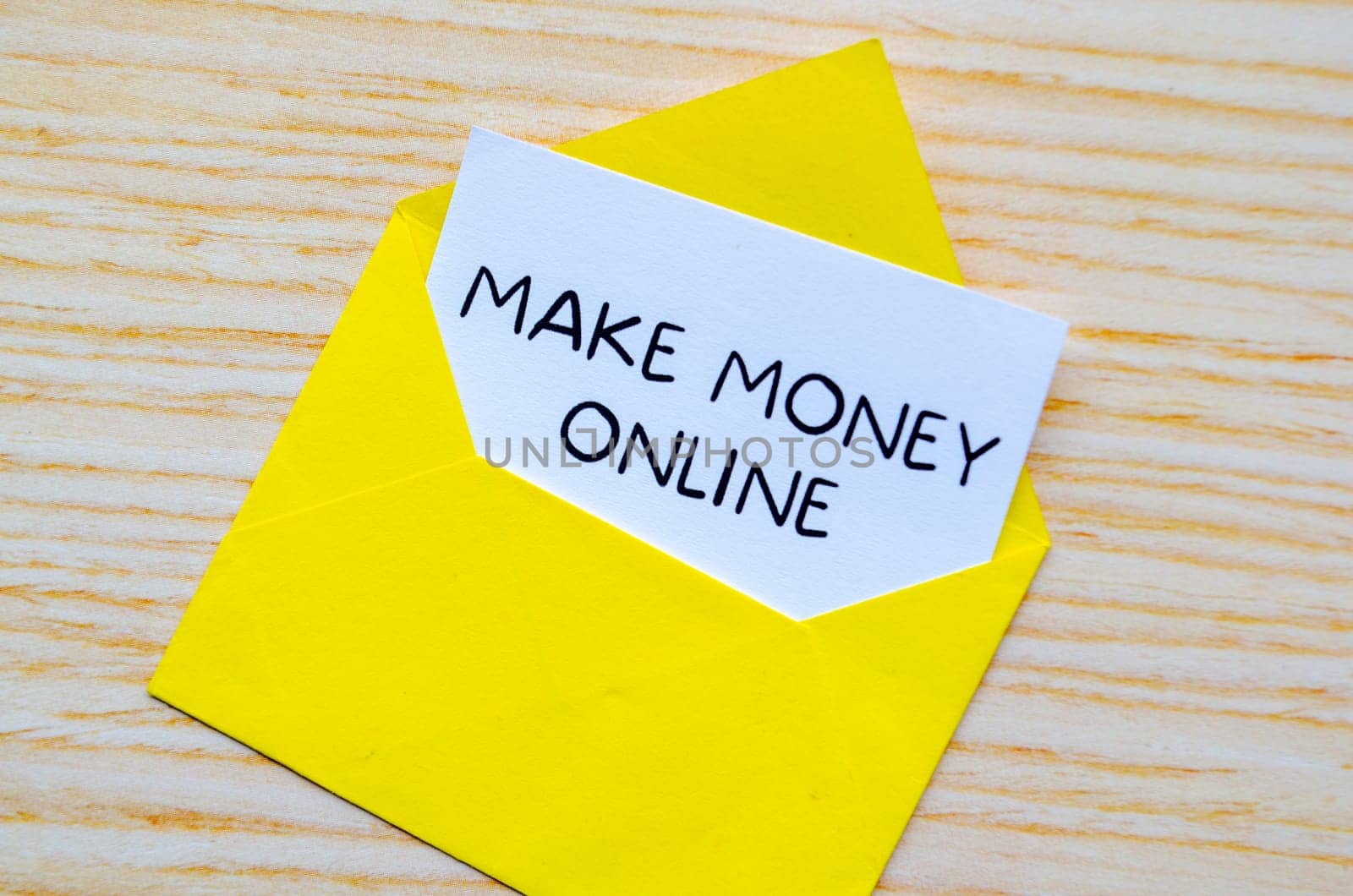 Make Money Online text on white notepad inside a yellow envelope. Making money online concept.
