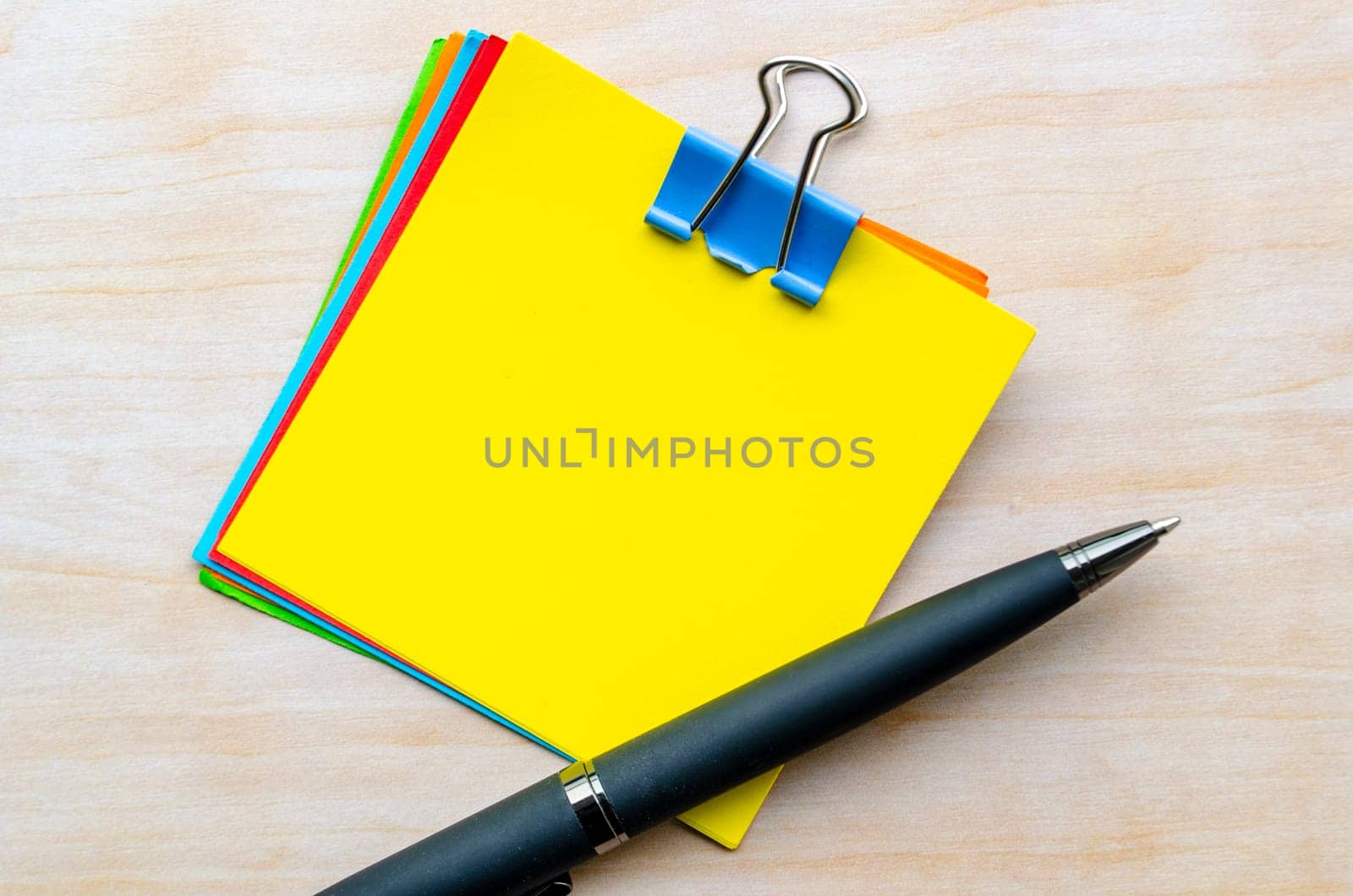 Top view of yellow notepad and pen with customizable space for text.
