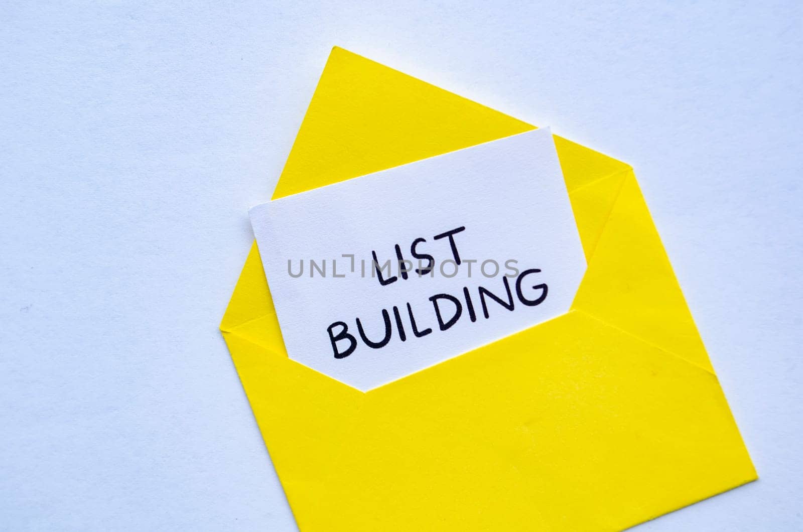 List building text on white notepad inside a yellow envelope. Making money online concept.