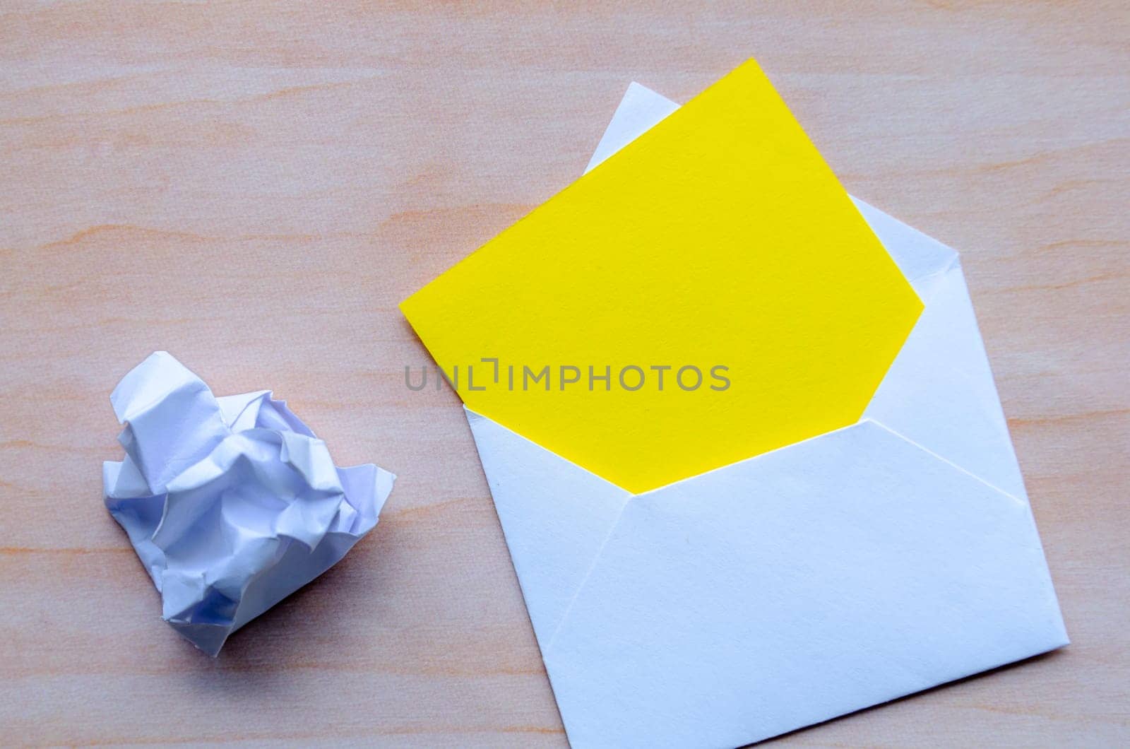 Top view of empty yellow notepad inside an envelope with customizable space for text.