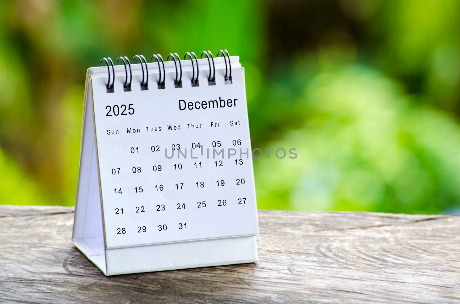 December 2025 white table calendar with outdoor background. Calendar concept.