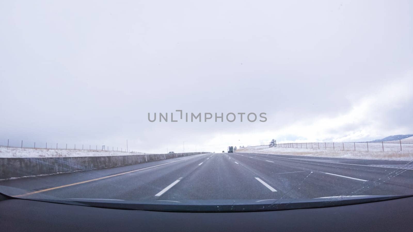 The open highway invites a peaceful drive, with snow-clad pines lining I-25 as the journey continues from Denver towards Colorado Springs on a snowy day.