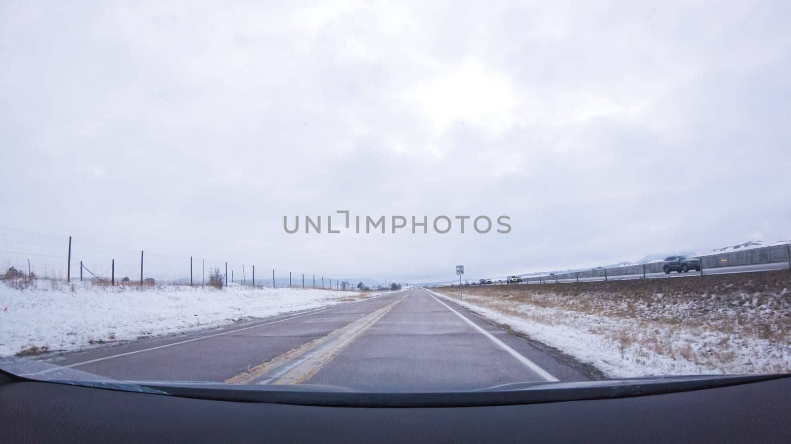 The open highway invites a peaceful drive, with snow-clad pines lining I-25 as the journey continues from Denver towards Colorado Springs on a snowy day.