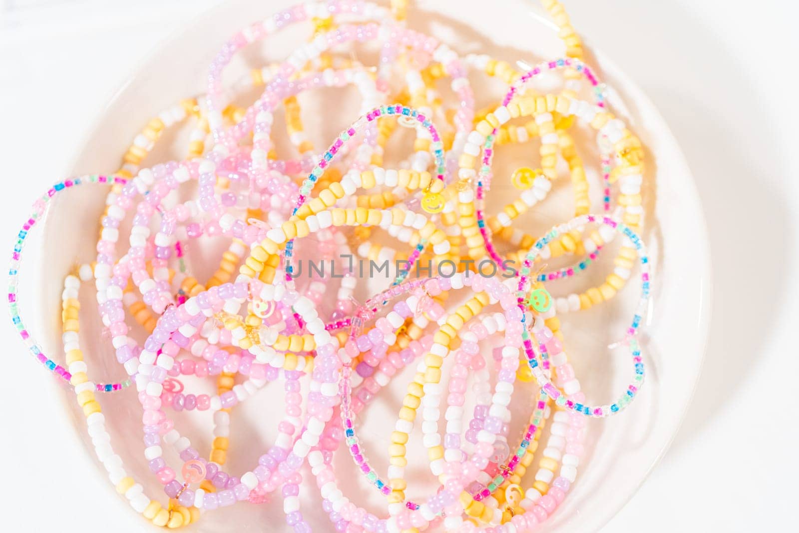 Little girl's charming bracelets adorned with clay and sea beads.