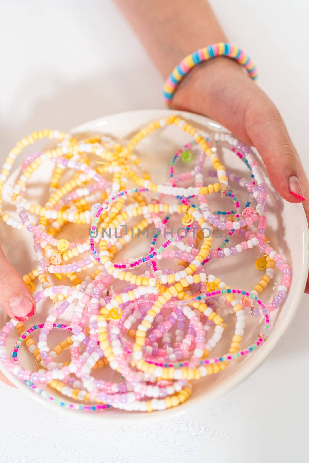 Little girl's charming bracelets adorned with clay and sea beads.
