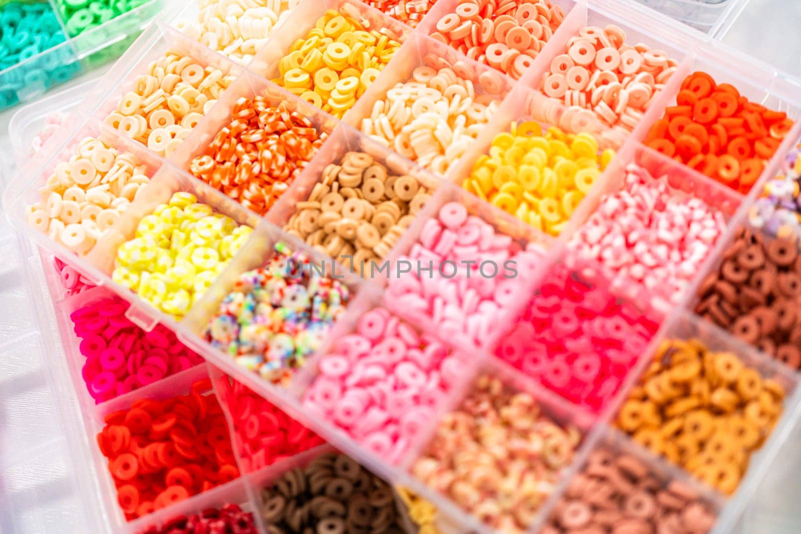 Assorted clay bead boxes neatly arranged on a white table, awaiting a creative kids' craft project.