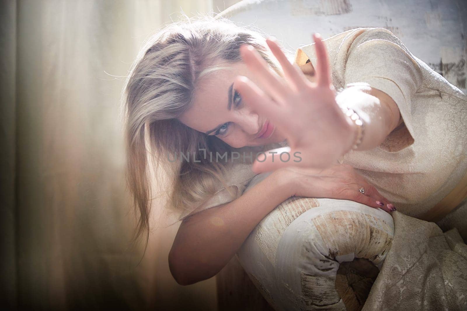 A middle-aged blonde blogger showcases her unique lifestyle and fashion in an indoor creative photo shoot.