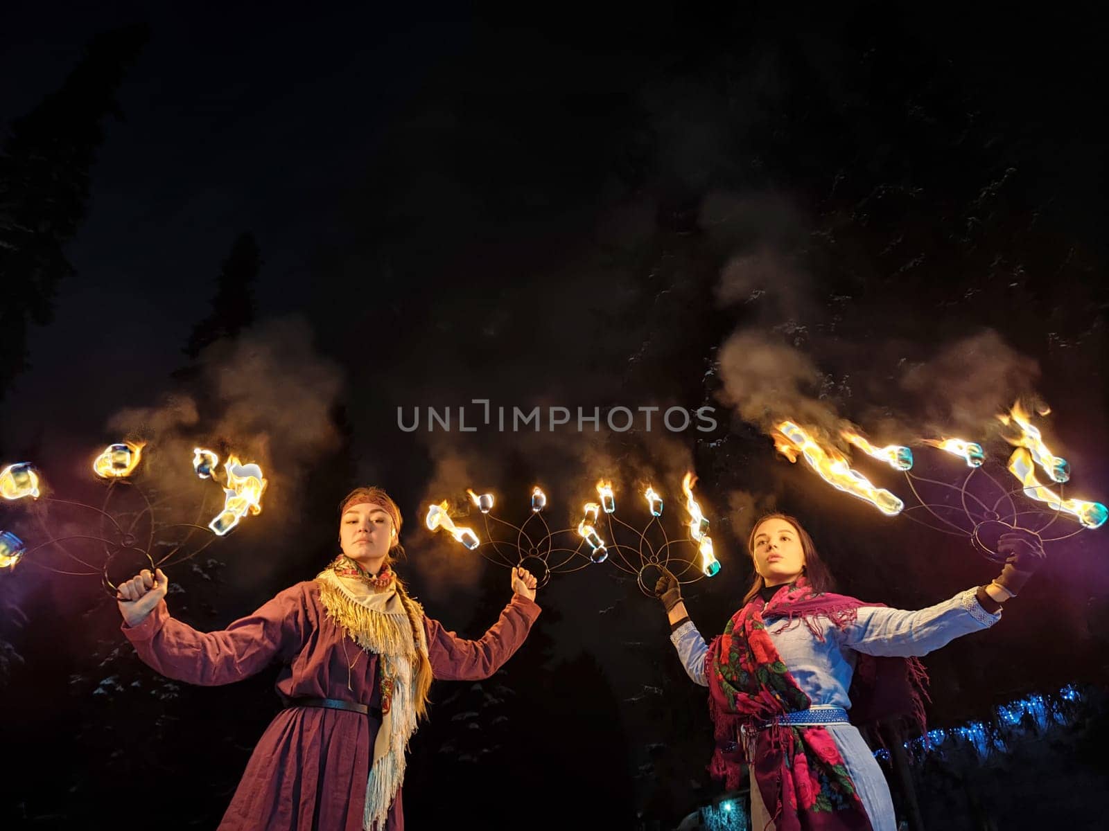 Actors in ethnic costumes perform a captivating fire show, celebrating Viking culture amid the winter chill and frosty ambiance of the night.